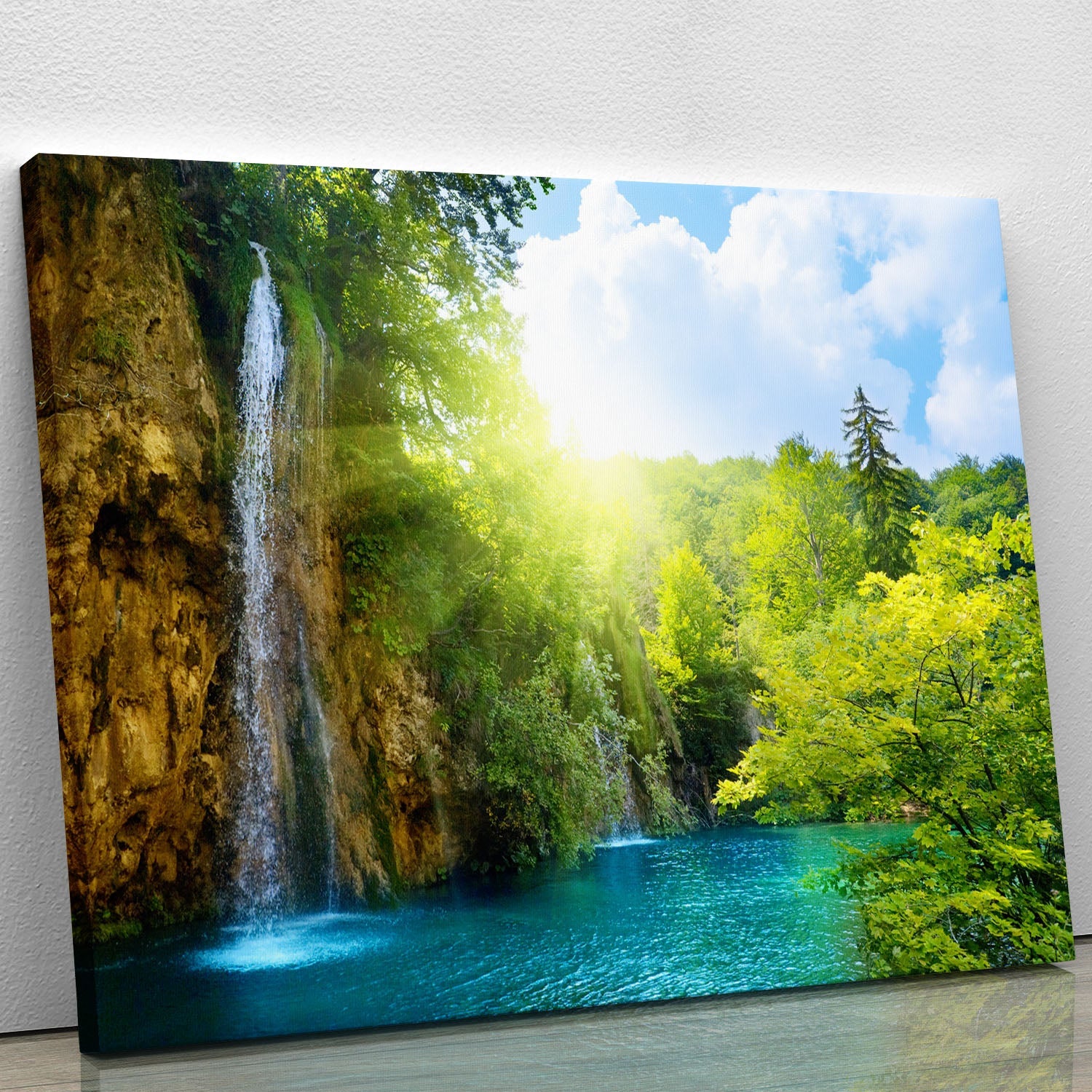 A beautiful canvas print featuring a serene waterfall in a deep forest, surrounded by lush greenery and vibrant colors.