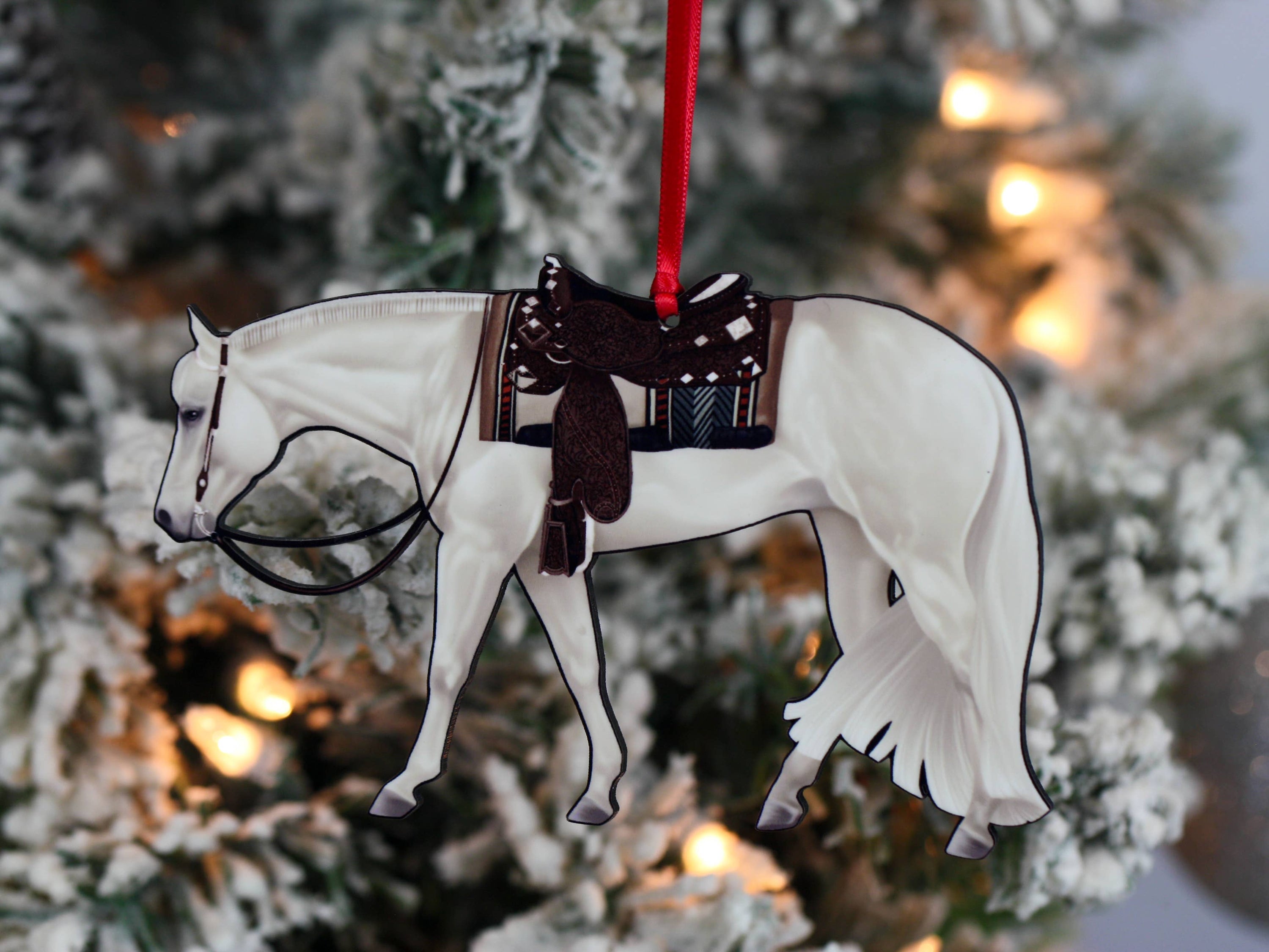 Gray and white Quarter Horse ornament made of composite wood, featuring red and black ribbons for hanging.