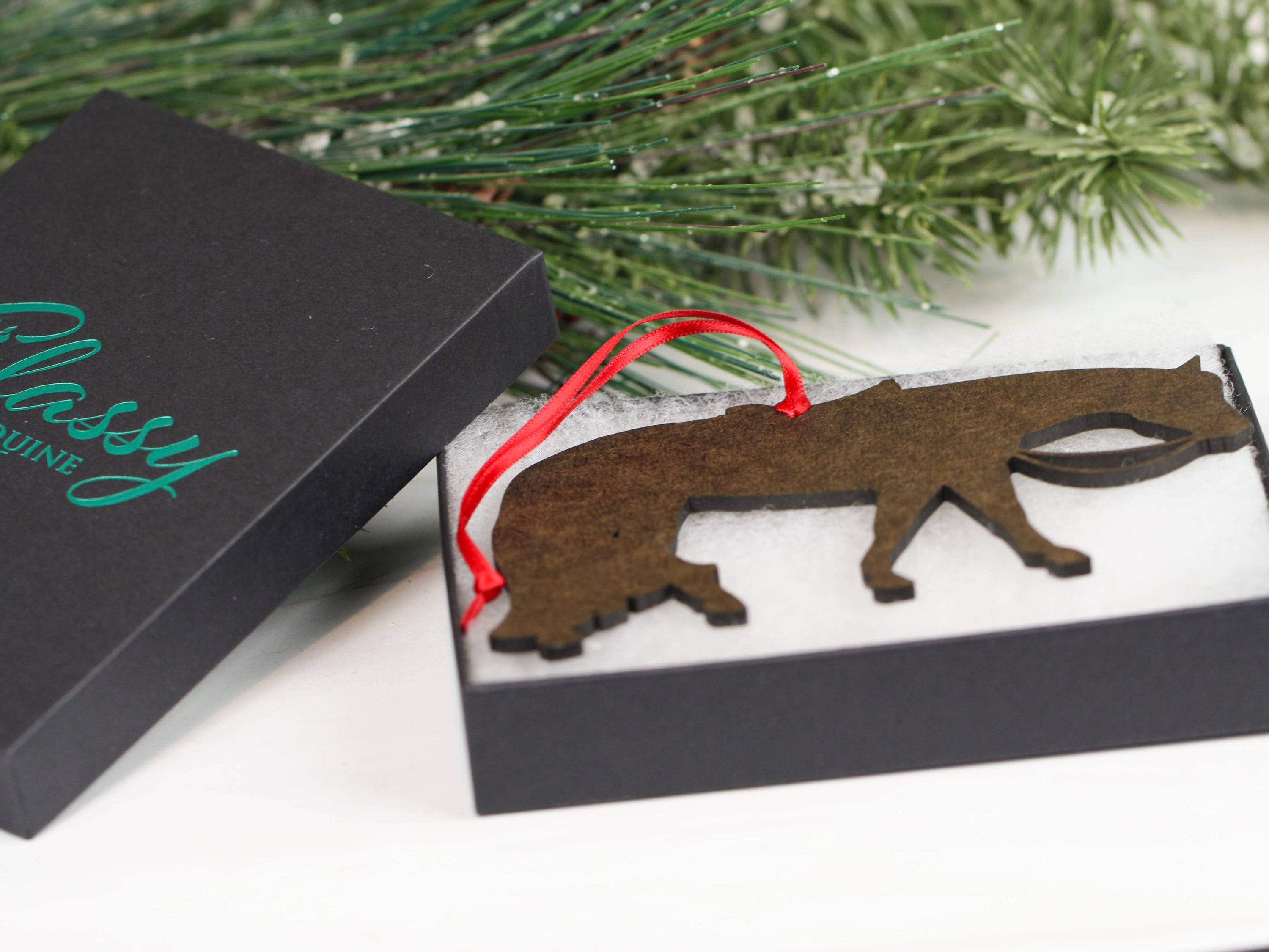 Gray and white Quarter Horse ornament made of composite wood, featuring red and black ribbons for hanging.