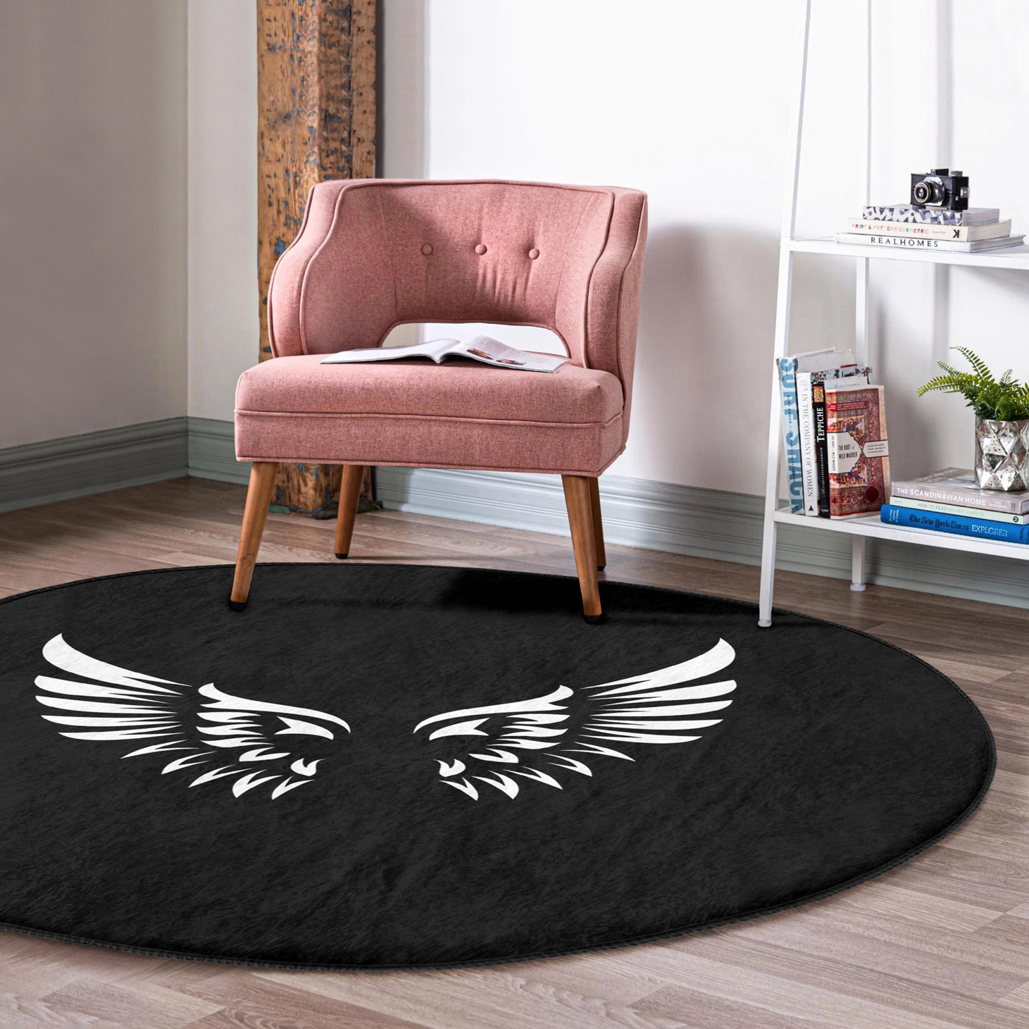 A round rug featuring white angel wings design on a black background, showcasing its soft velvet texture and elegant appearance.