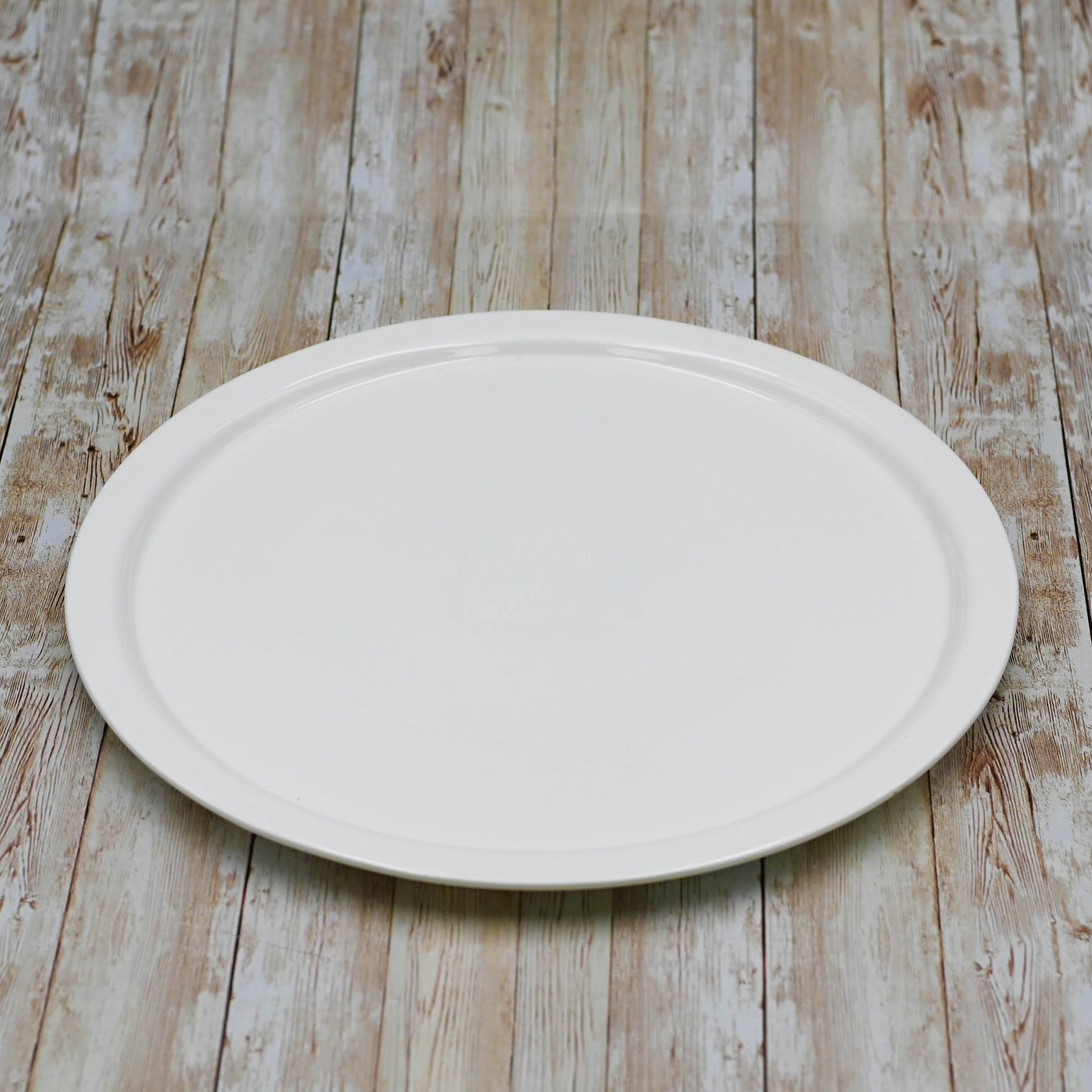 A stylish 14-inch white porcelain pizza plate with a rolled chip-resistant rim, perfect for serving pizzas elegantly.