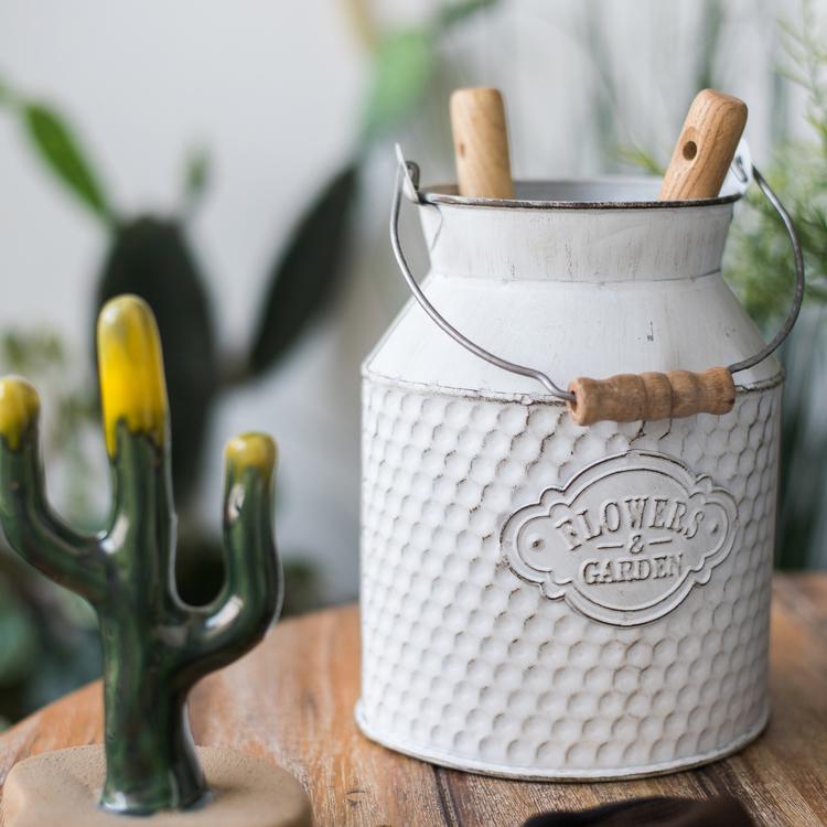A charming white small iron flower garden barrel with a decorative design, perfect for planting flowers or small plants.