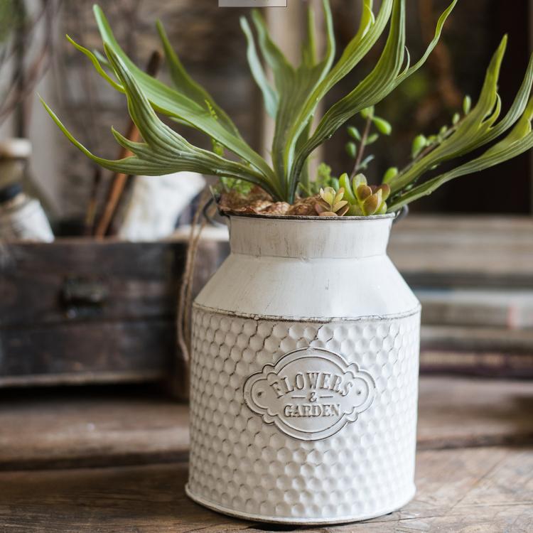 A charming white small iron flower garden barrel with a decorative design, perfect for planting flowers or small plants.