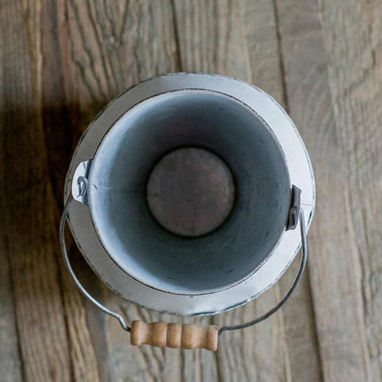 A charming white small iron flower garden barrel with a decorative design, perfect for planting flowers or small plants.