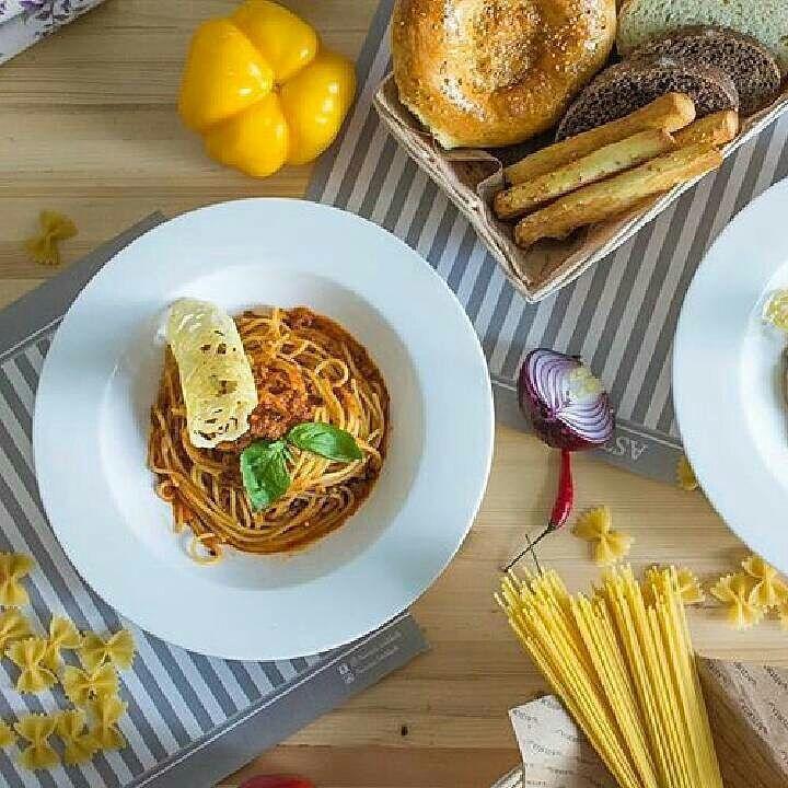 A pristine white porcelain soup plate, 9 inches in diameter, showcasing its elegant design and rolled rim, perfect for serving soups and stews.