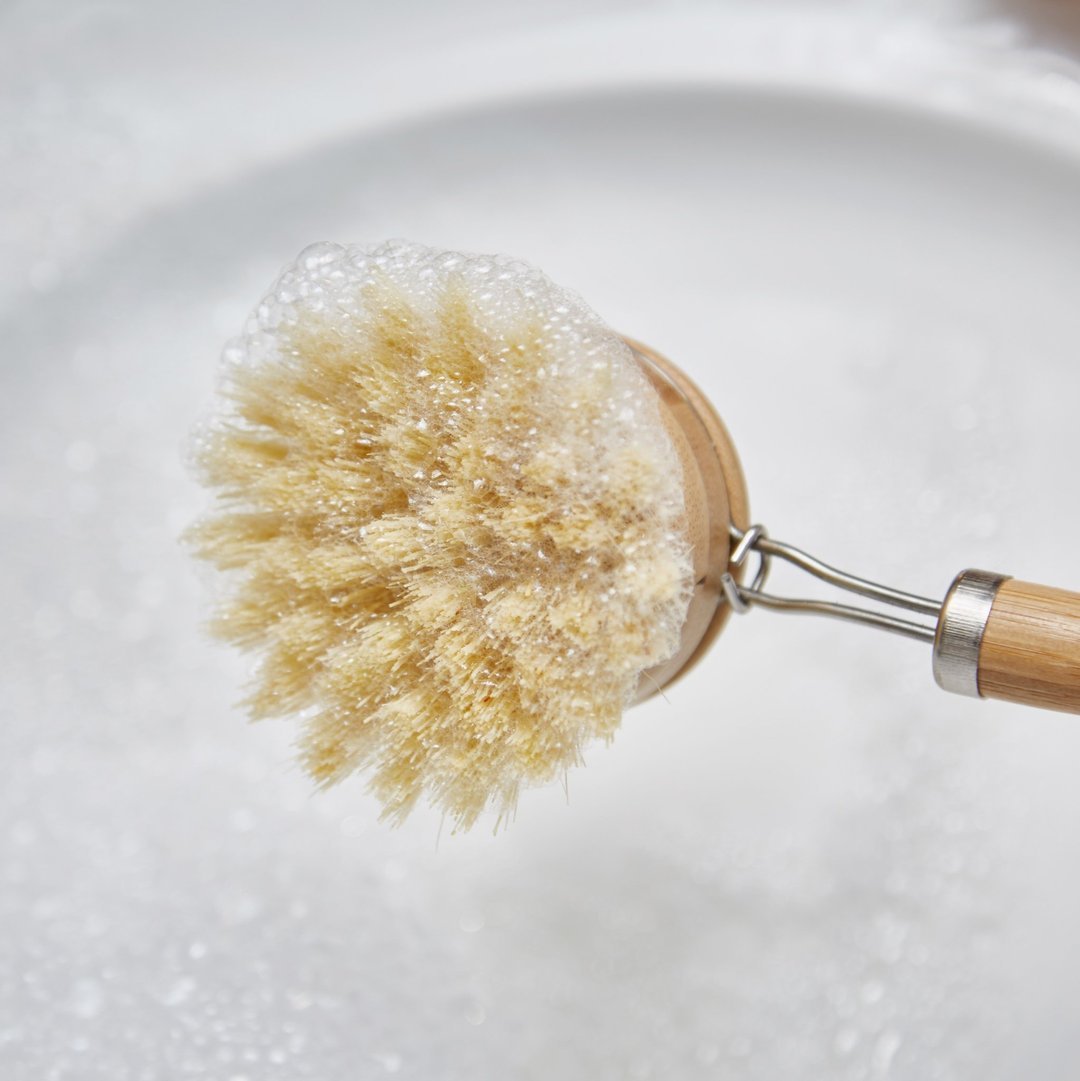 A sustainable wooden dish brush with a bamboo handle and sisal bristles, featuring two replacement brush heads for eco-friendly cleaning.