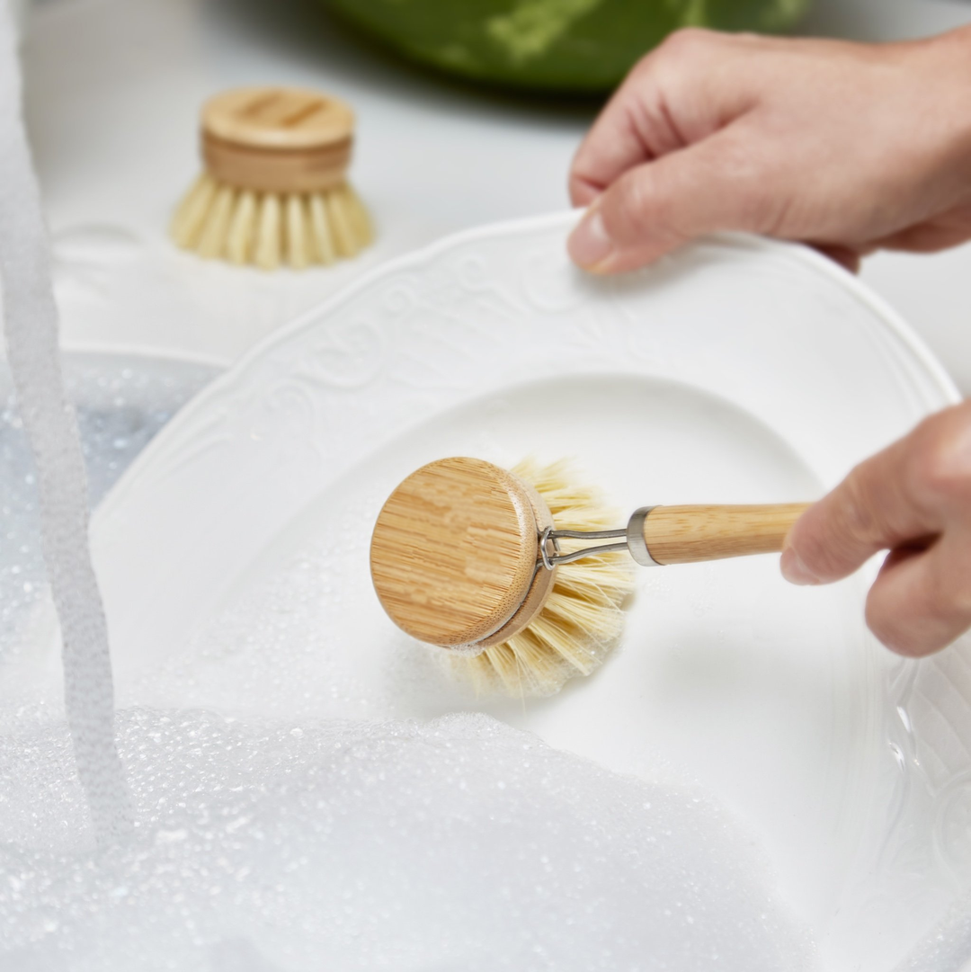 A sustainable wooden dish brush with a bamboo handle and sisal bristles, featuring two replacement brush heads for eco-friendly cleaning.