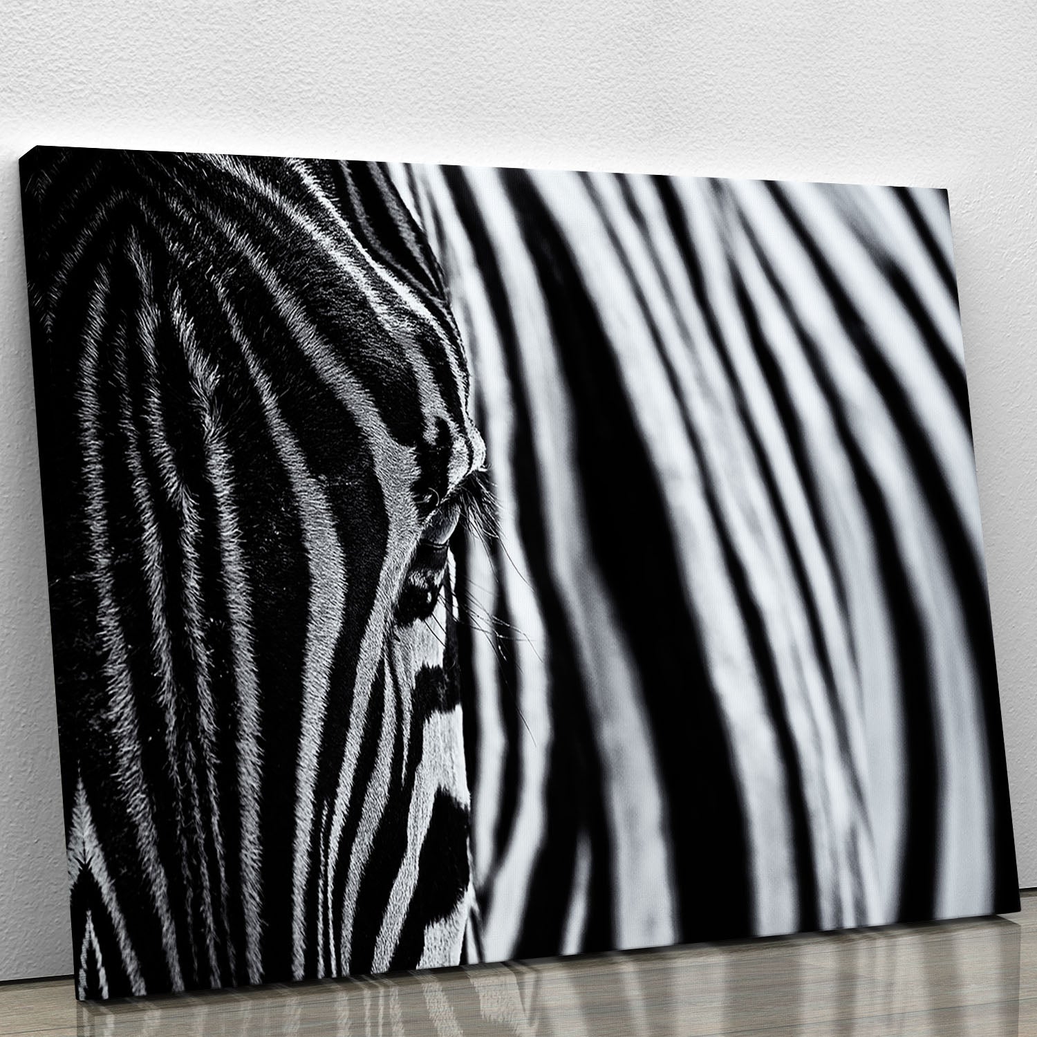 A close-up view of a zebra's face, showcasing its unique black and white stripes on a canvas print.