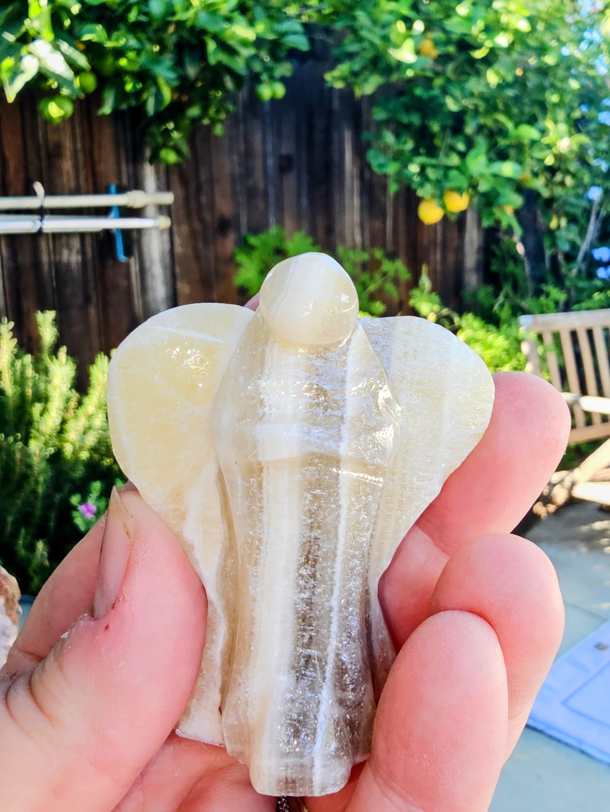 Hand-carved Zebra Onyx Angel sculpture showcasing yellow, gray, white, and black bands.
