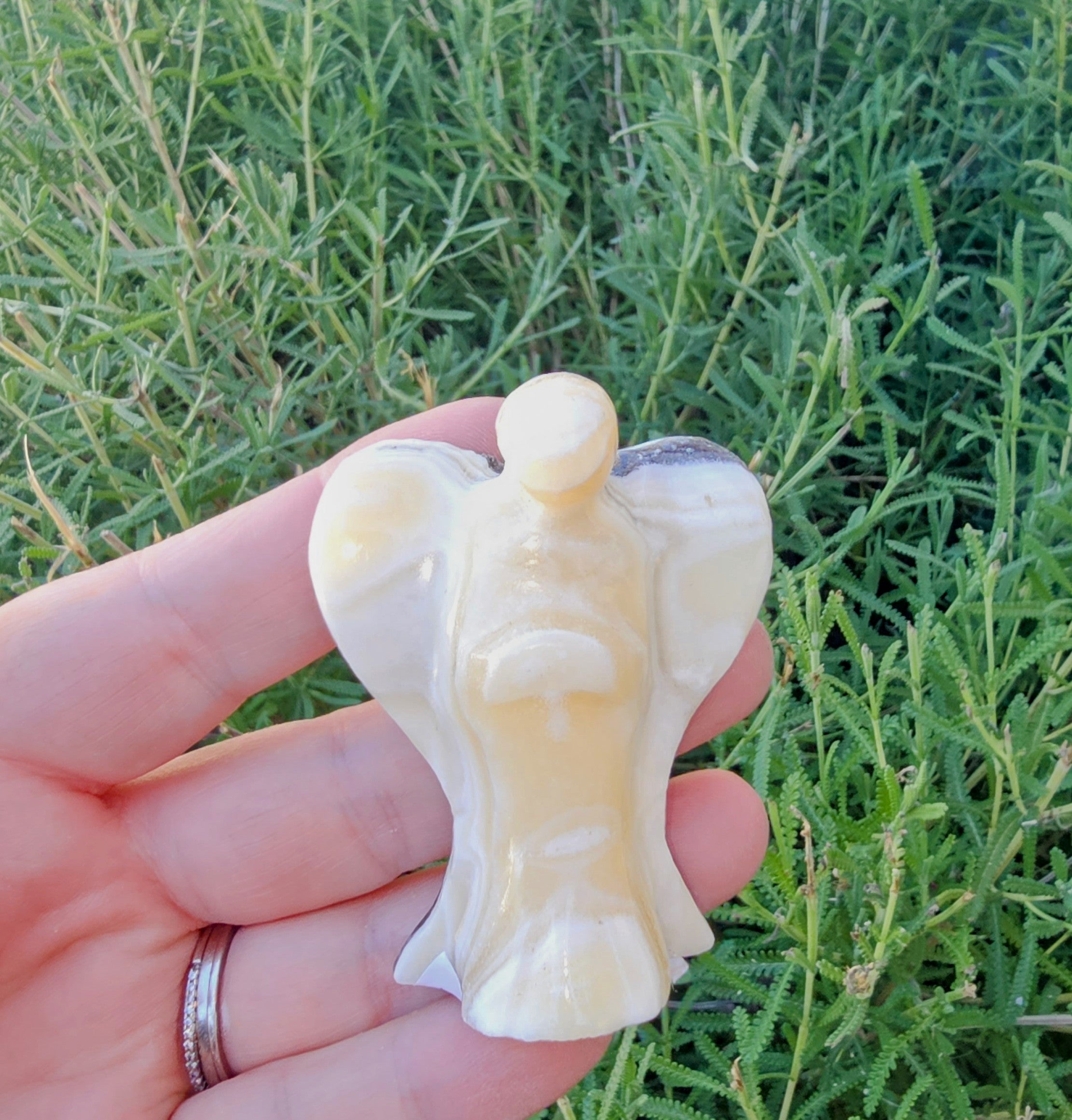 Hand-carved Zebra Onyx Angel sculpture showcasing yellow, gray, white, and black bands.