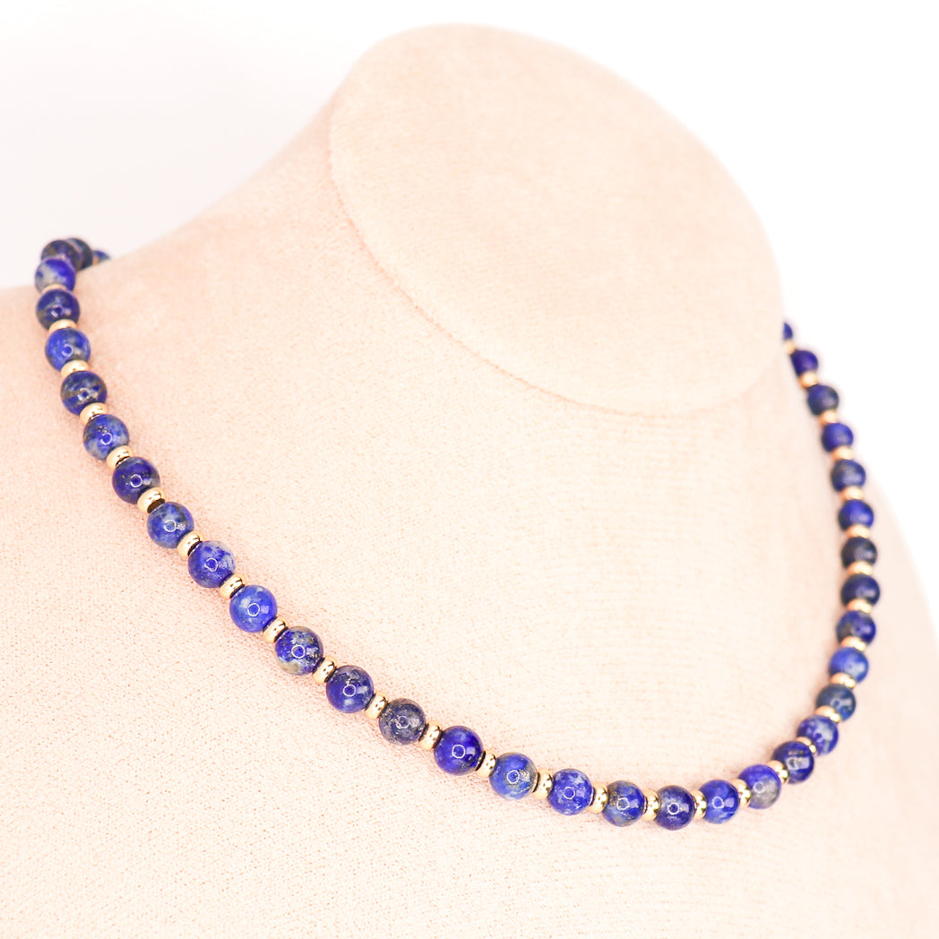 Collier en Lapis lazuli naturel avec plaquage Or 18 et 24 carats, élégant et artisanal, sur fond neutre.