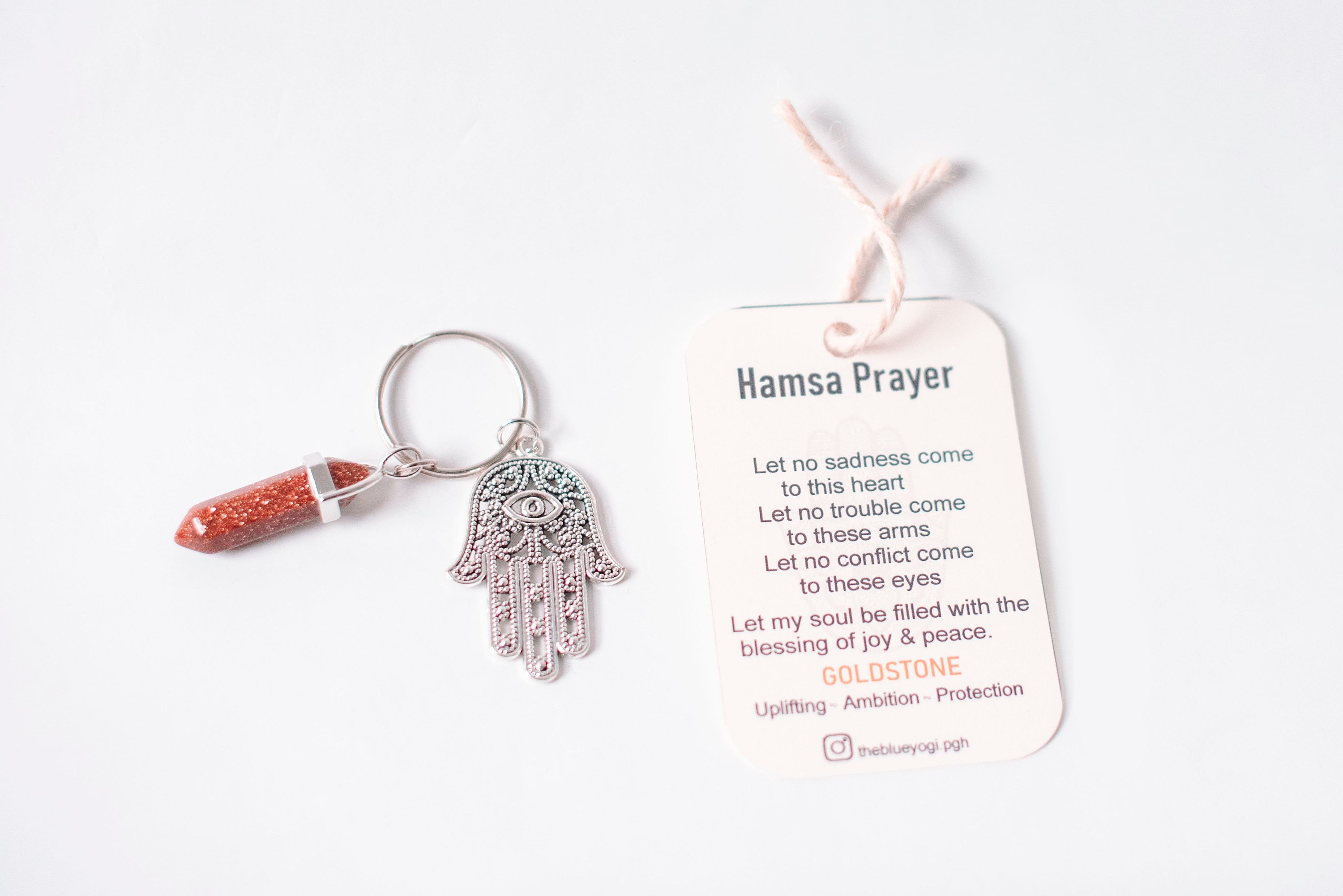 Hamsa & Goldstone Key chain featuring a protective Hamsa symbol and shimmering Goldstone charm, accompanied by a Hamsa Prayer Card.