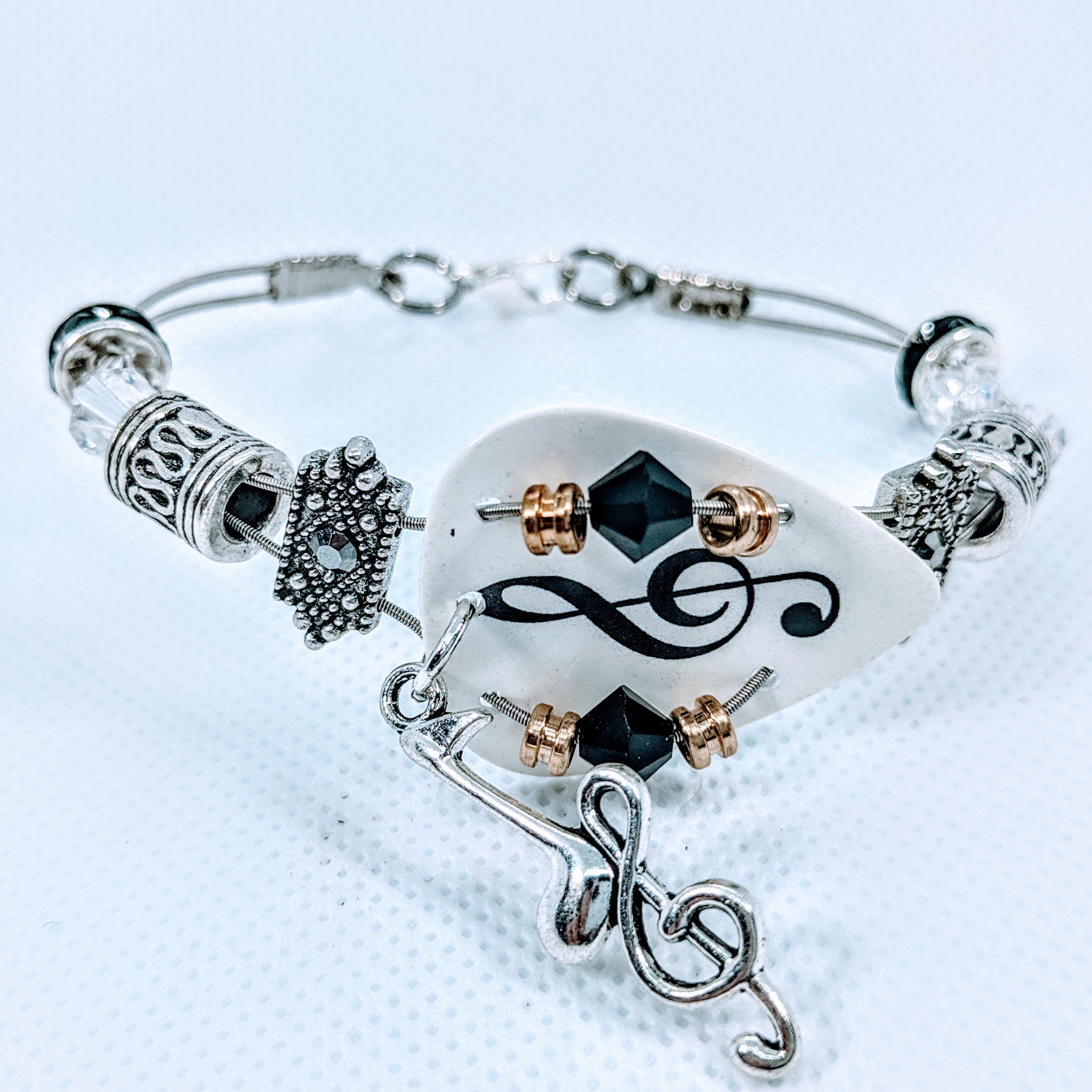 Handmade bracelet made from guitar strings featuring Swarovski™ crystals and a treble clef charm, perfect for music lovers.