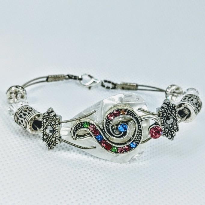 Handmade guitar string bracelet adorned with Swarovski™ crystals, featuring a treble clef design, perfect for music lovers.