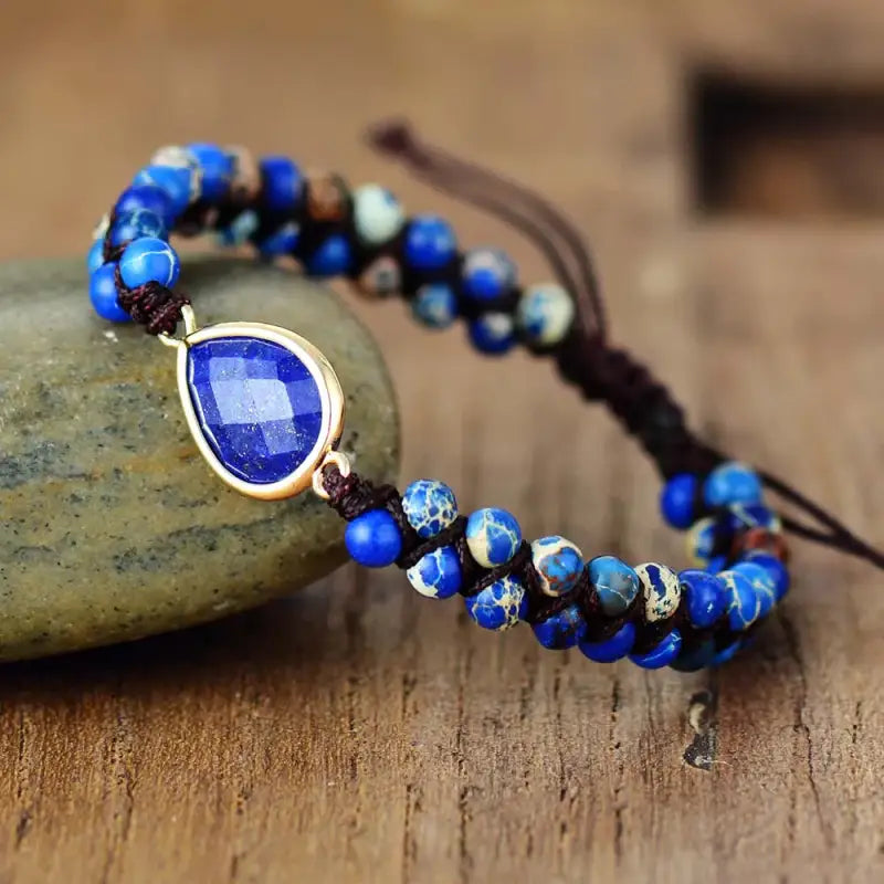 Lapis Lazuli Teardrop Charm Bracelet featuring deep blue gemstones and gold flecks, elegantly designed for unisex wear.