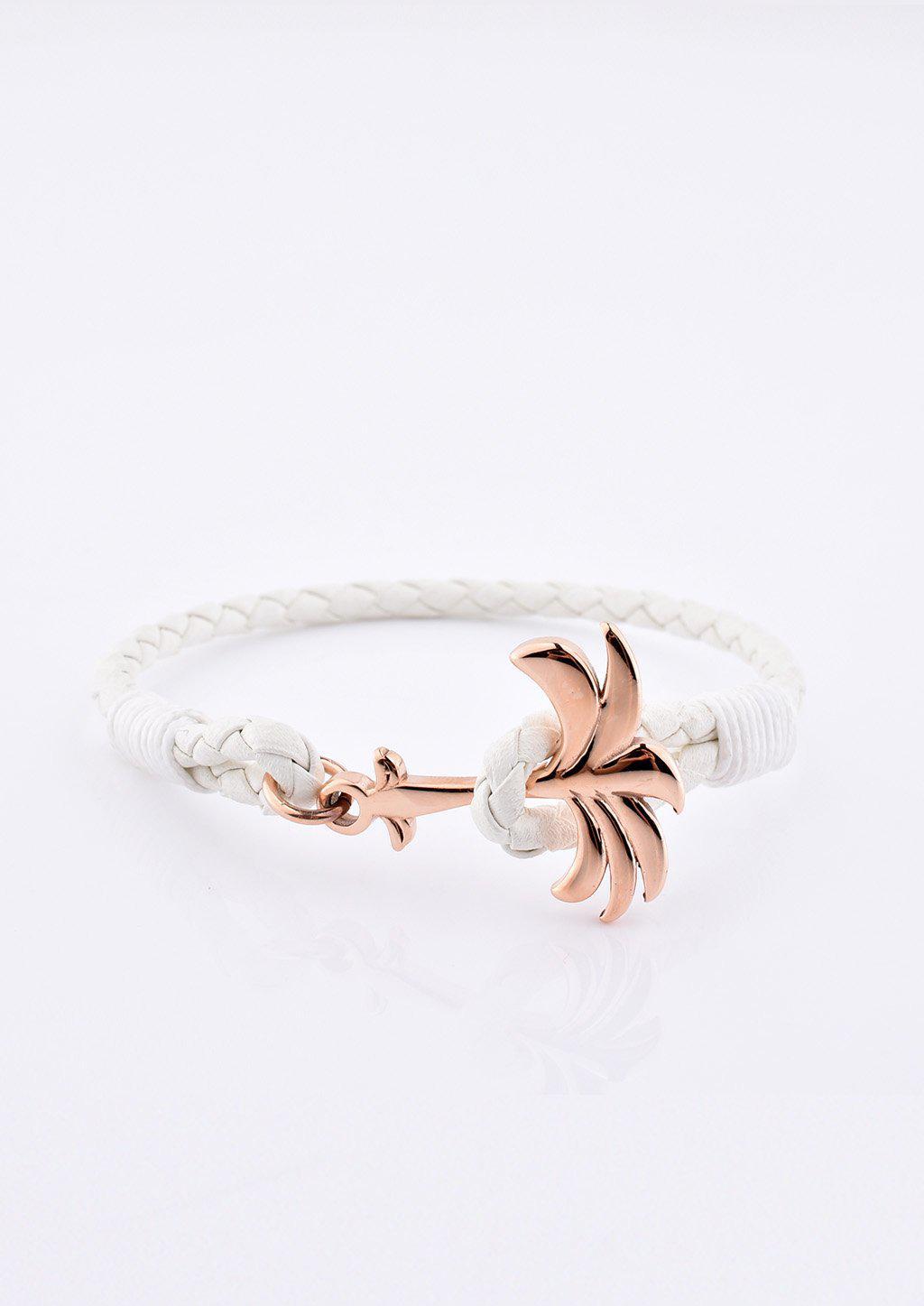 A stylish Serene Palm Band bracelet featuring a white leather band and a unique rose gold palm tree charm.