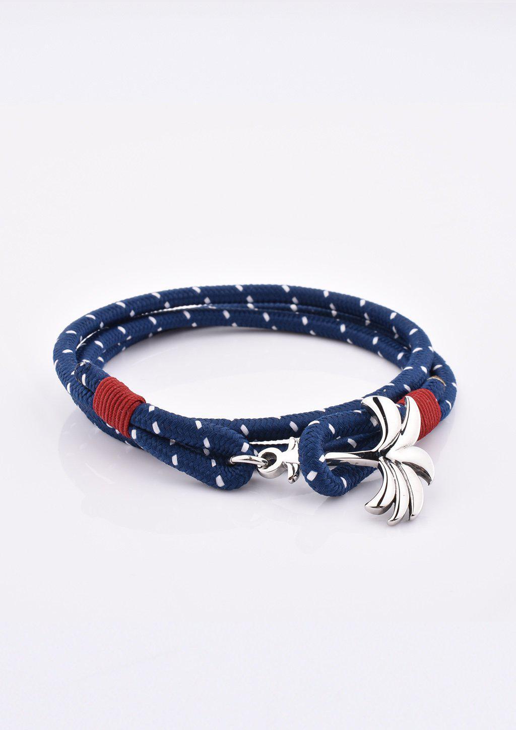 Palmband Voyager Triple bracelet featuring a silver palm tree anchor on a blue and red nylon band, symbolizing adventure and positivity.