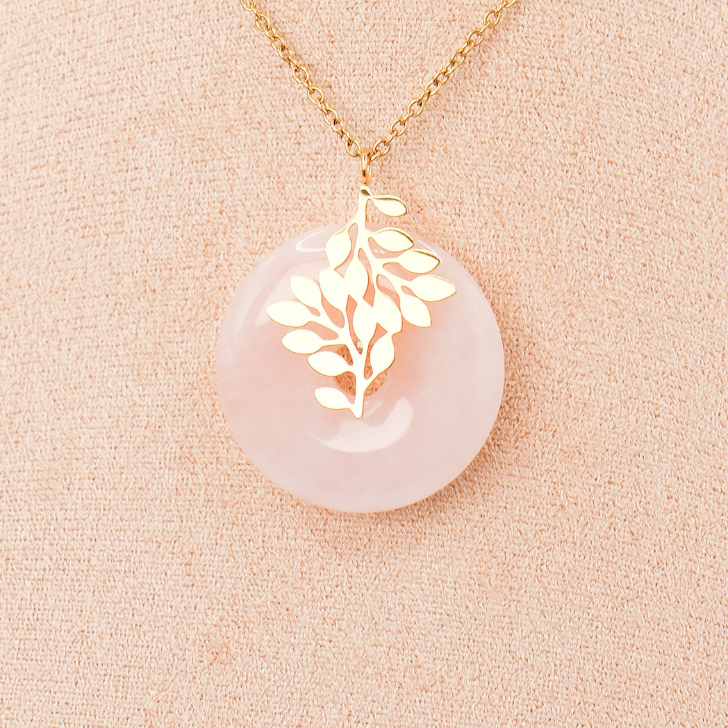 Pendentif 'Vie d'amour' en Quartz rose avec feuilles d'arbre en acier inoxydable doré, élégant et unique.