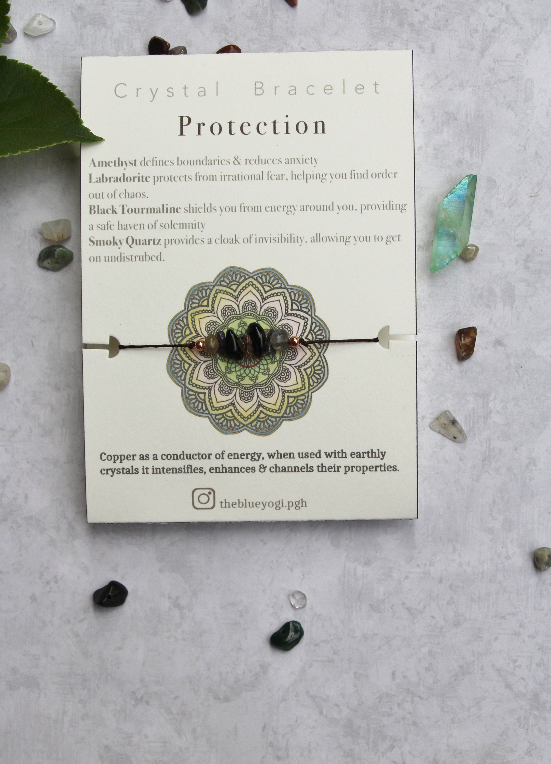 A casual and minimal protection crystal bracelet made of natural gemstones, featuring a tie closure and a watercolor Mandala art card.