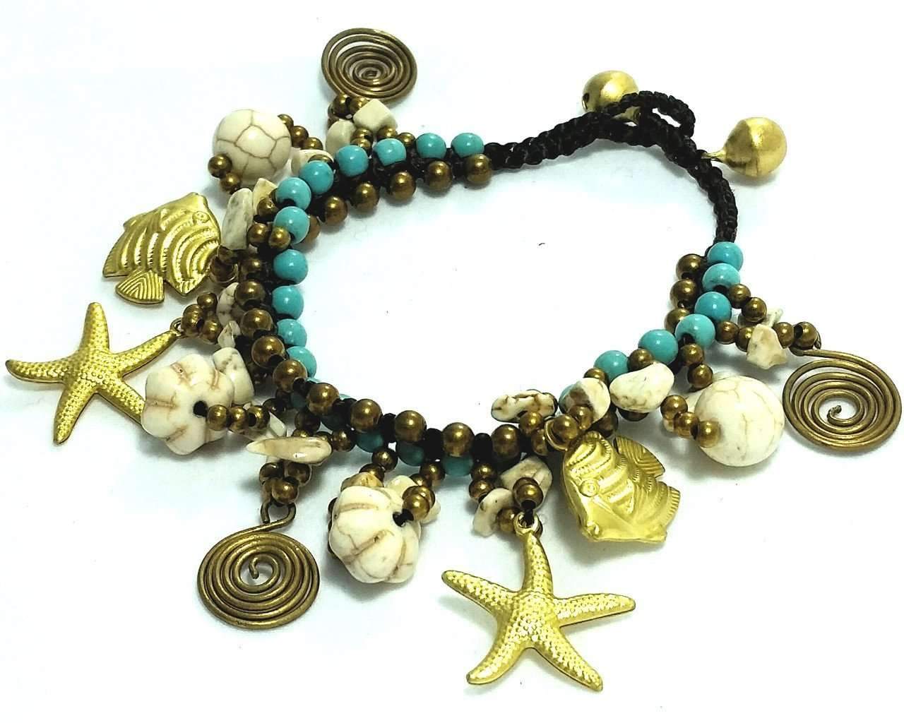 A beautifully handcrafted Sand & Surf Charm Bracelet featuring fish, starfish, and seashells with colorful beads and dark brass accents.