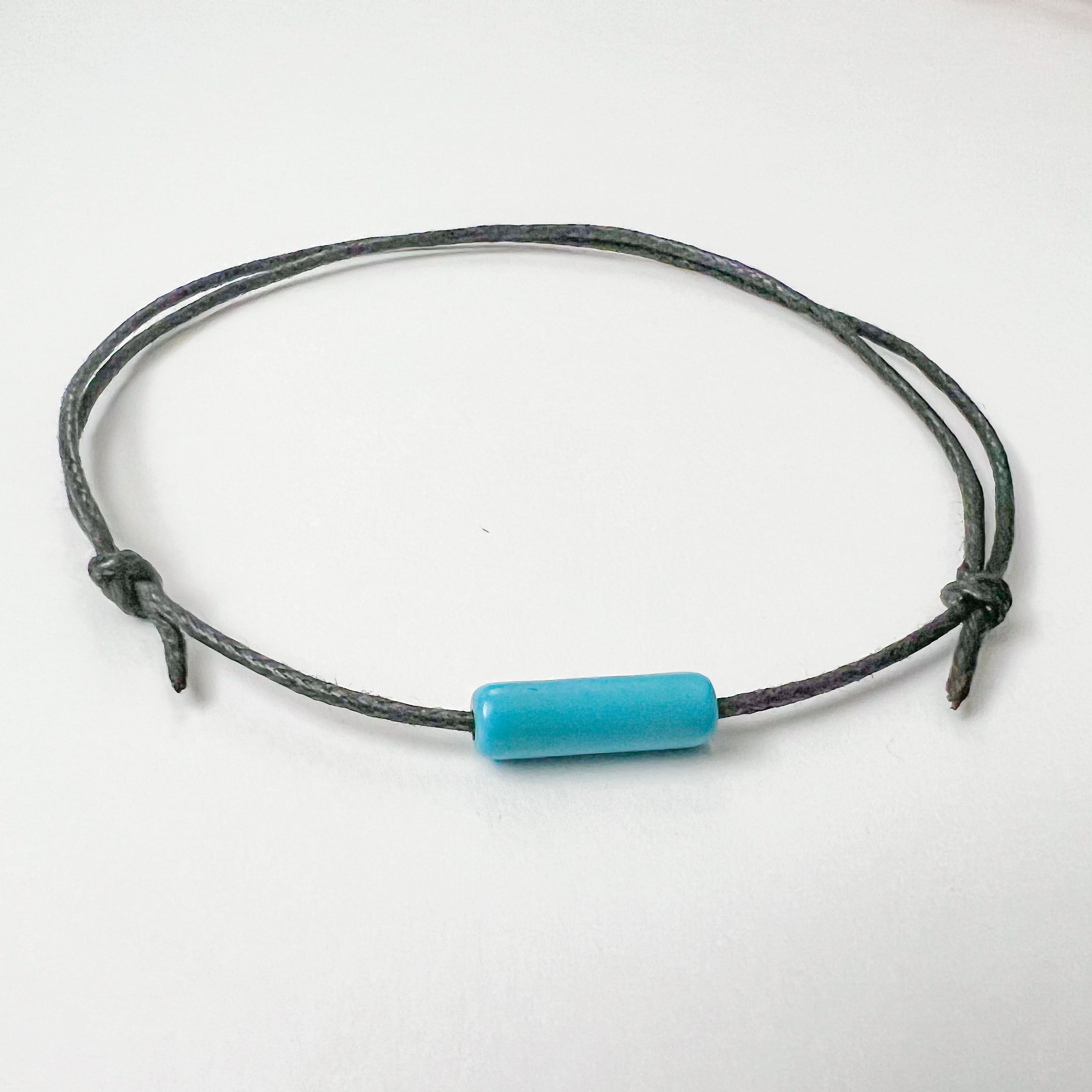 Turquoise Bar Minimal and Adjustable Anklet made with turquoise beads and waxed cotton cord, featuring a sliding knot for size adjustment.