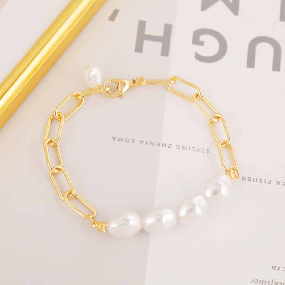 A stylish gold plated link bracelet adorned with faux pearl beads, showcasing elegance and versatility for women's fashion.