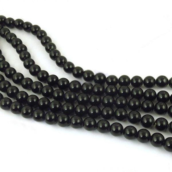 A strand of polished black onyx gemstone round beads, showcasing their smooth texture and deep color, perfect for jewelry making.