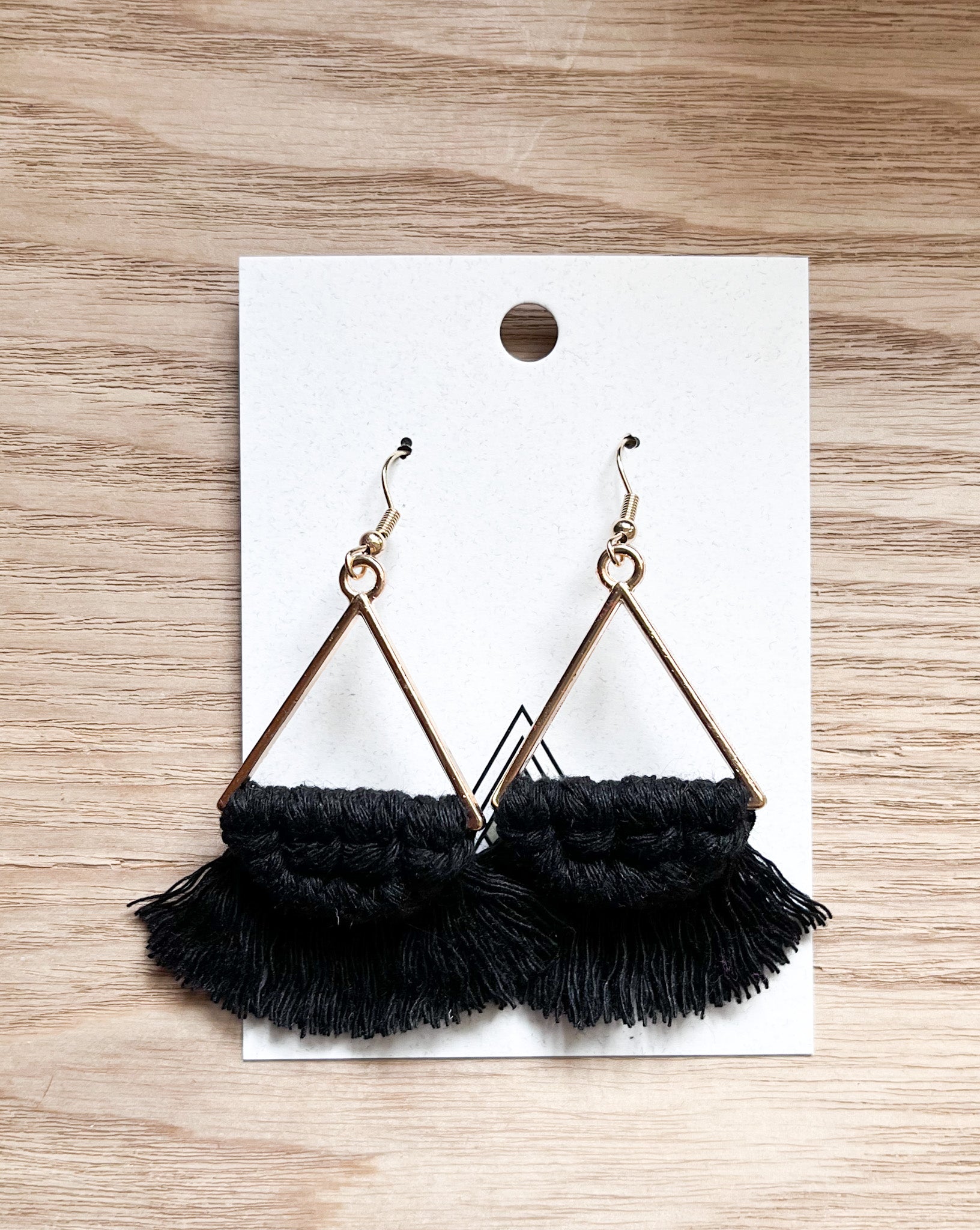 Elegant black triangle earrings made from macrame cotton, showcasing a unique geometric design.