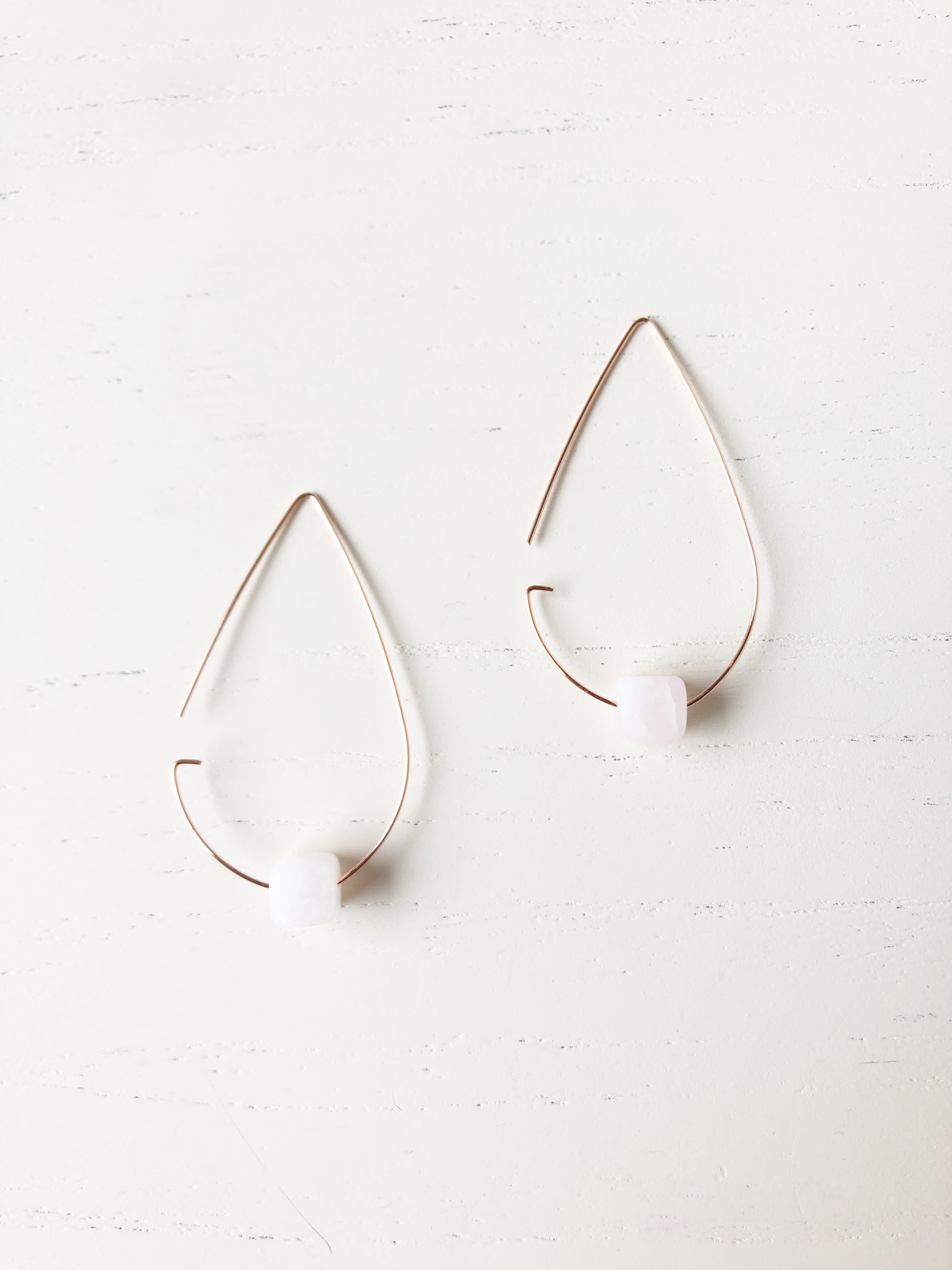 Brass tear drop threader earrings featuring rose quartz stones in rose gold, elegantly designed for stylish wear.