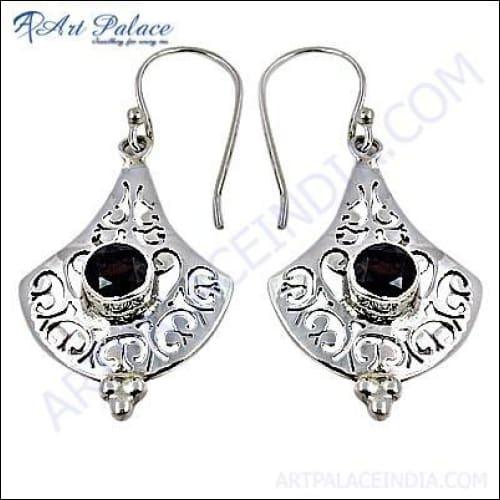 Elegant designer silver earrings featuring a vibrant garnet gemstone, showcasing unique craftsmanship and style.