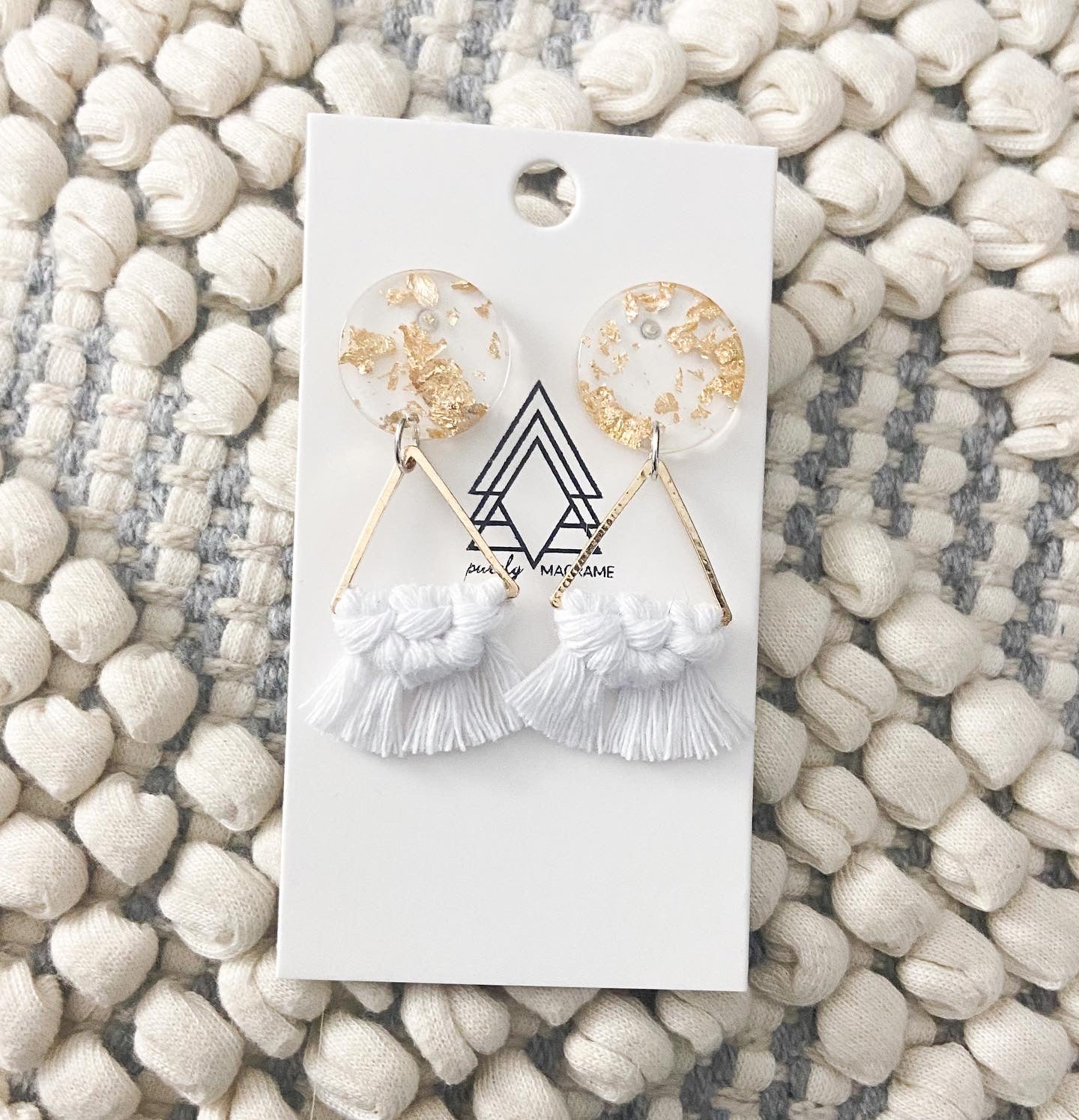 A pair of lightweight gold triangle earrings made from 100% macrame cotton, showcasing a stylish and modern design.