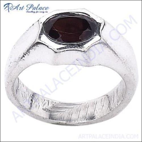 Handcrafted silver ring featuring a vibrant garnet gemstone, showcasing unique design and craftsmanship.