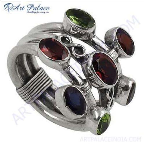 Handcrafted silver ring featuring garnet, iolite, and peridot gemstones, showcasing intricate design and vibrant colors.