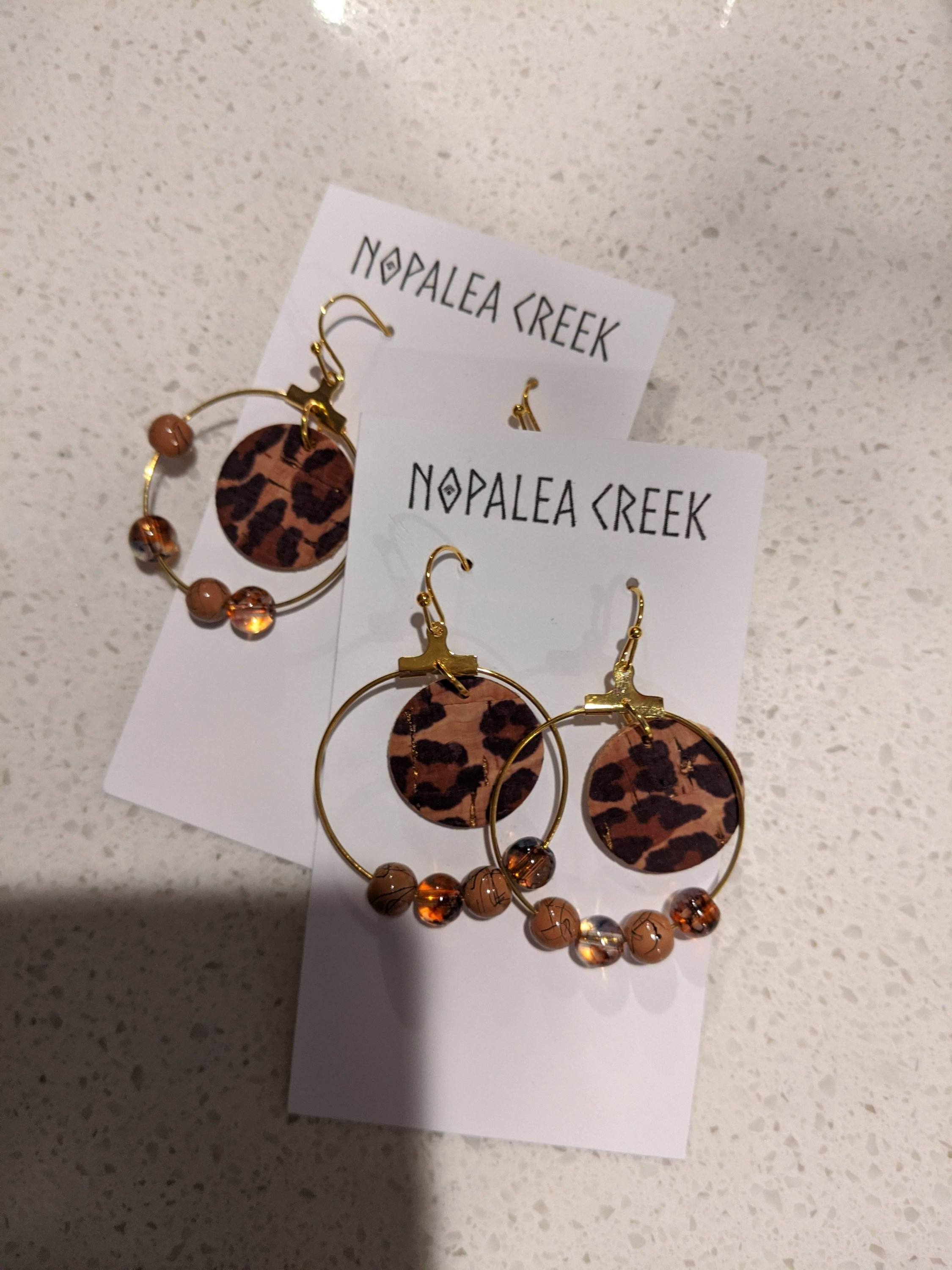 A pair of handmade cork leopard dangle earrings featuring a unique leopard print design, lightweight and stylish for any occasion.