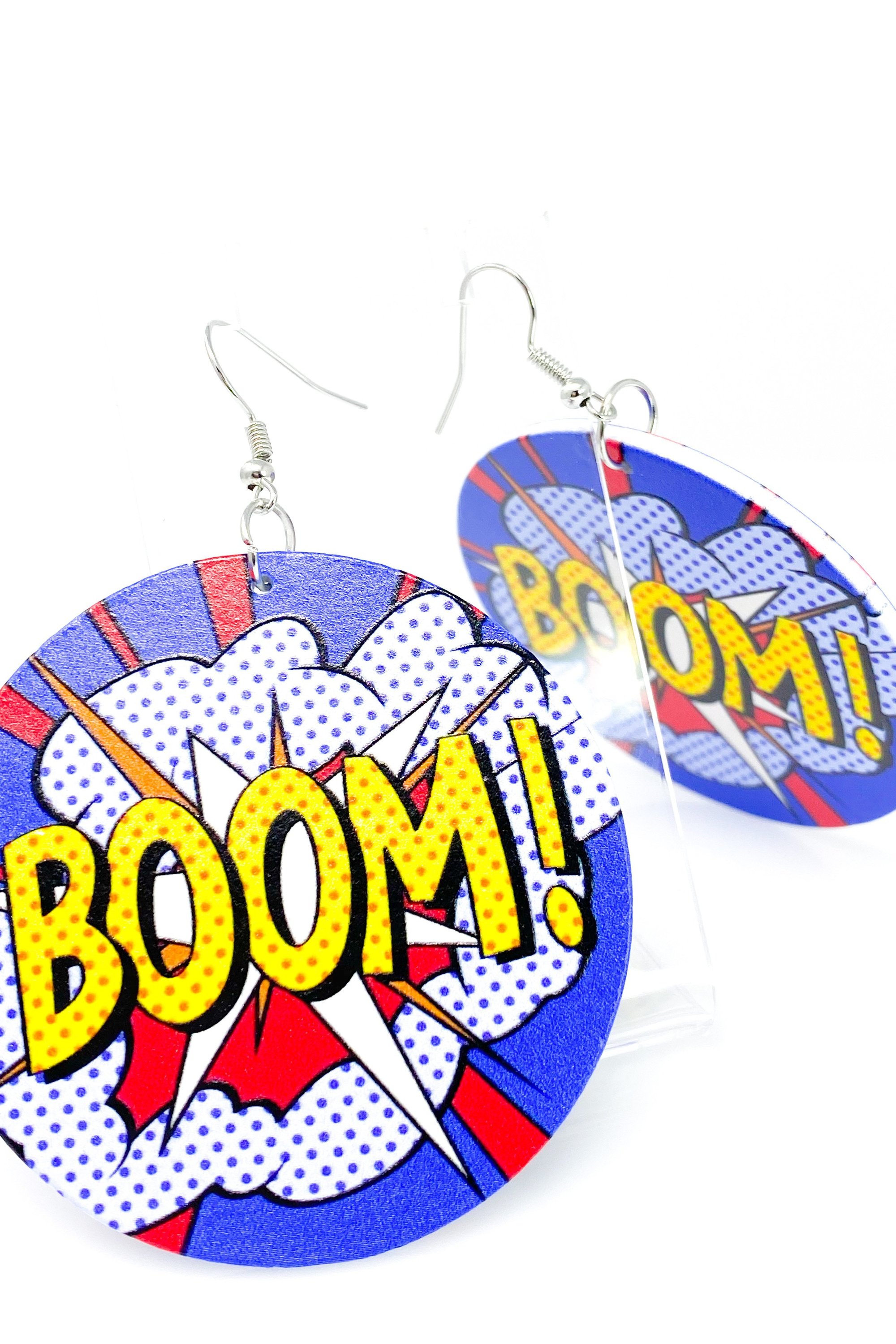 Colorful wooden hoop earrings in white, blue, and red, featuring brass ear hooks, showcasing a stylish and cultural design.