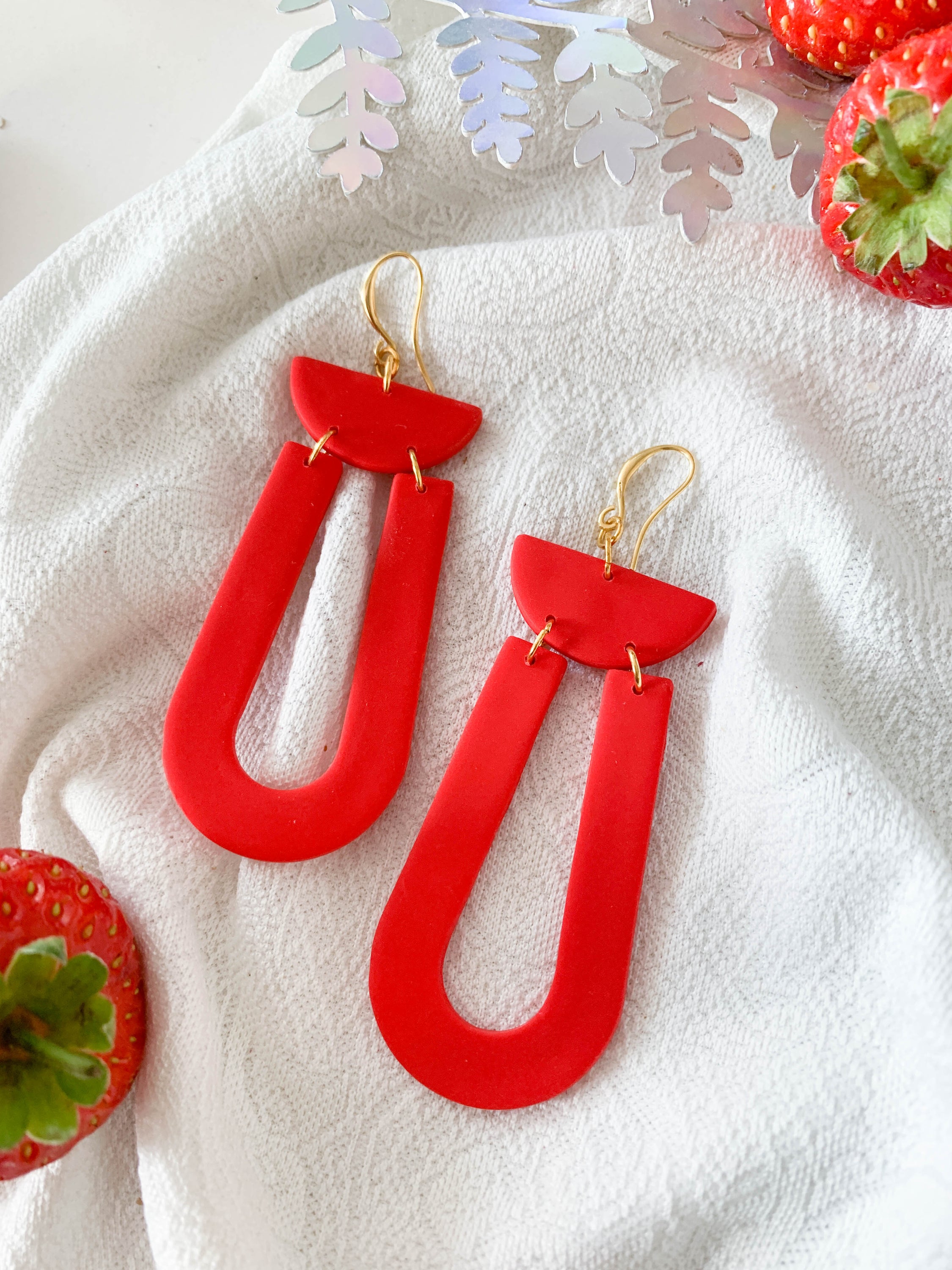 Josie Strawberry earrings featuring vibrant red loops and 24k gold plated brass hooks, perfect for adding a pop of color.