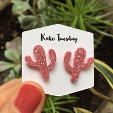 A pair of vibrant pink cactus-shaped sparkly acrylic earrings, showcasing a unique and playful design.
