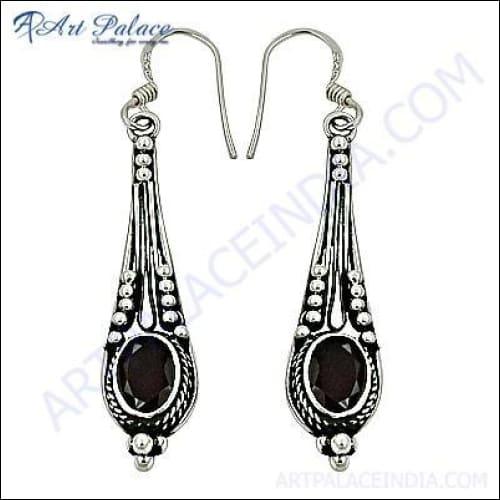 A pair of elegant silver earrings featuring deep red garnet gemstones, showcasing intricate design and craftsmanship.