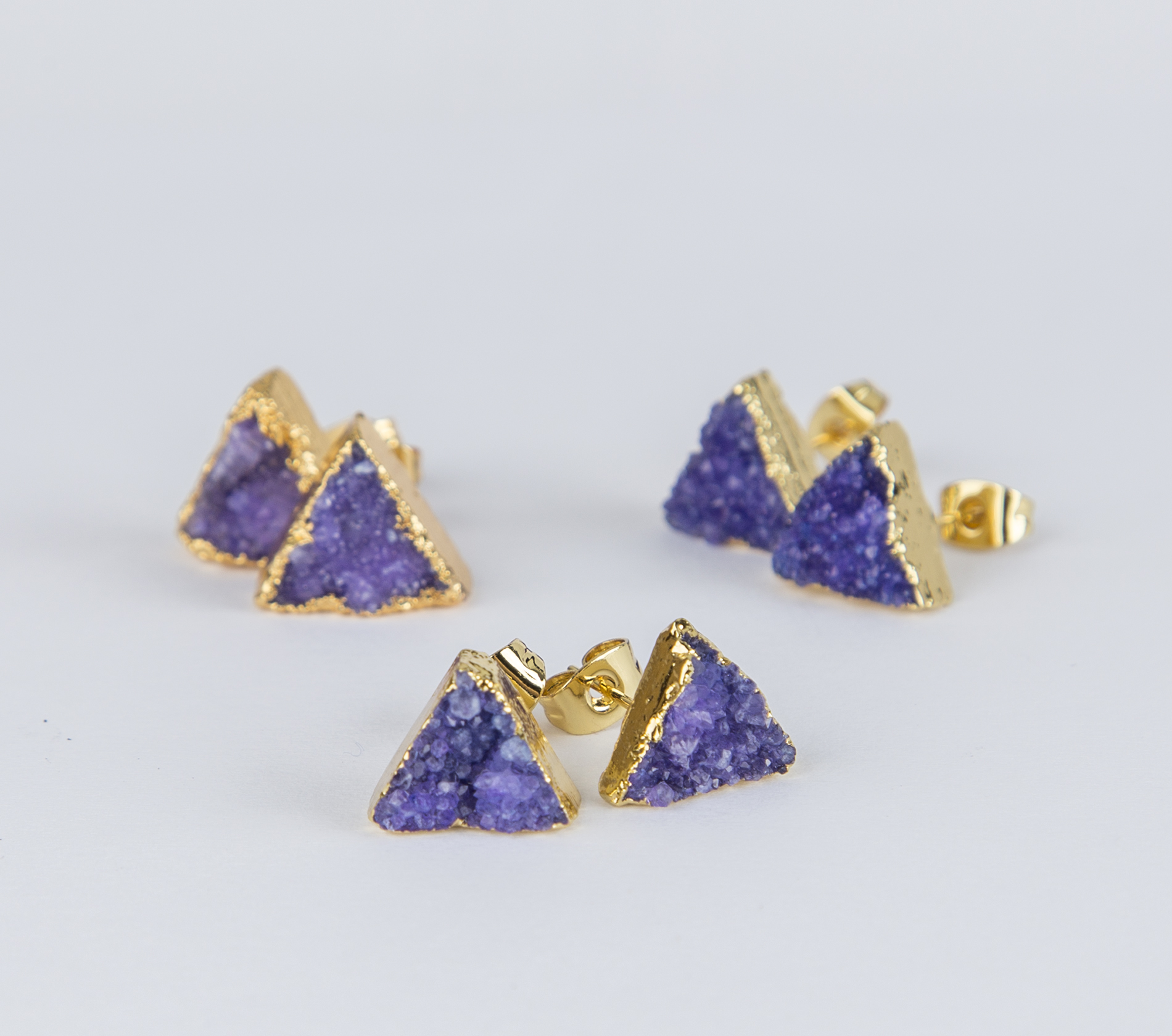 Elegant purple triangle druzy earrings with gold plated studs, showcasing their sparkly texture and natural stone design.