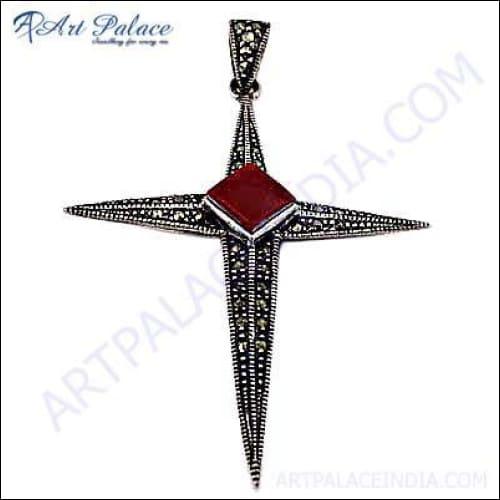 A unique handmade silver cross pendant featuring a vibrant red coral gemstone, showcasing intricate craftsmanship and elegant design.