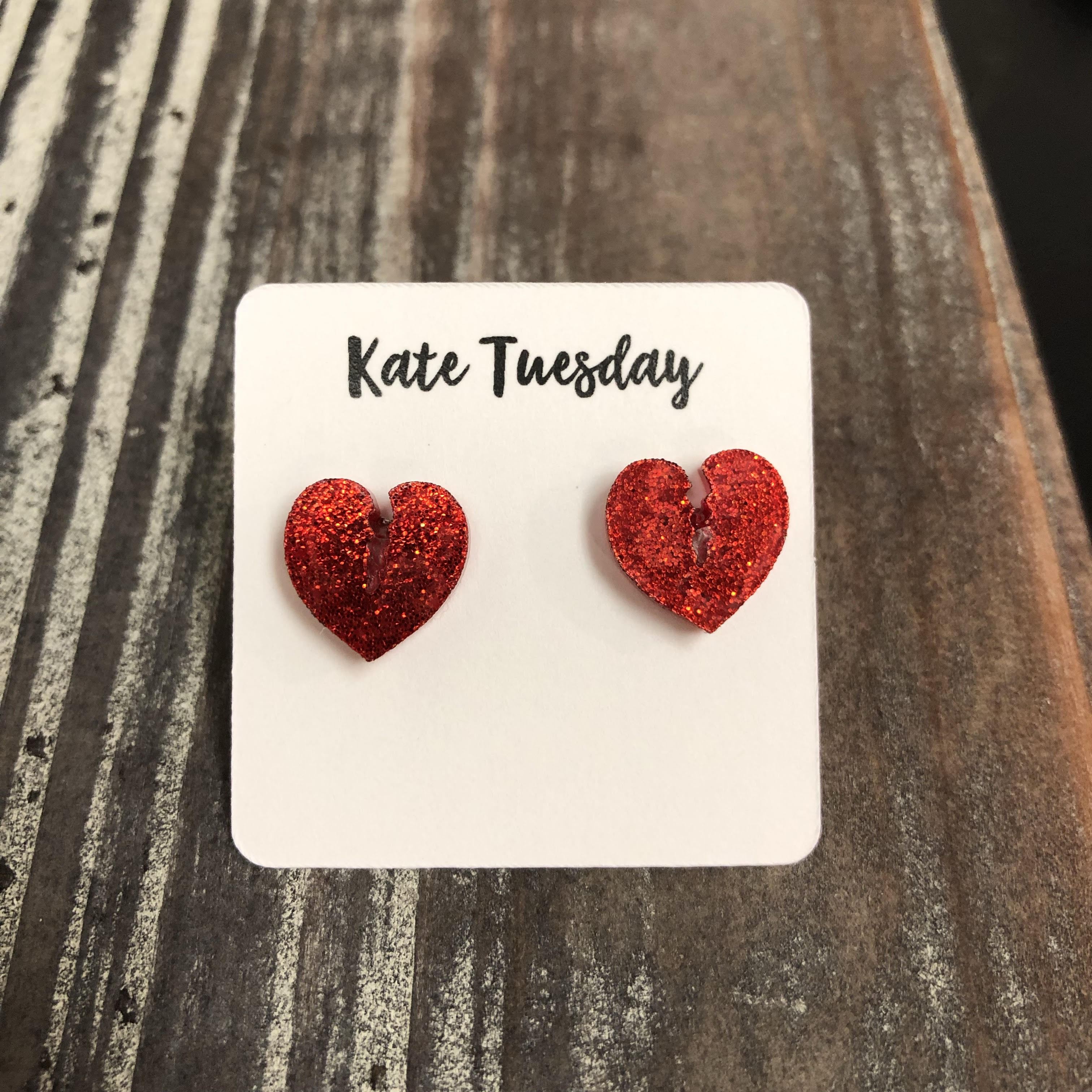 A pair of red glitter broken heart earrings, showcasing a vibrant design with a shiny finish, perfect for adding a playful touch to any outfit.