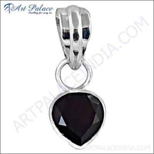 A stunning dark red garnet gemstone set in an elegant silver pendant, showcasing intricate craftsmanship and vibrant color.