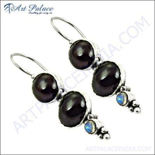 A pair of stunning handmade silver earrings featuring garnet and labradorite stones, showcasing intricate craftsmanship and vibrant colors.