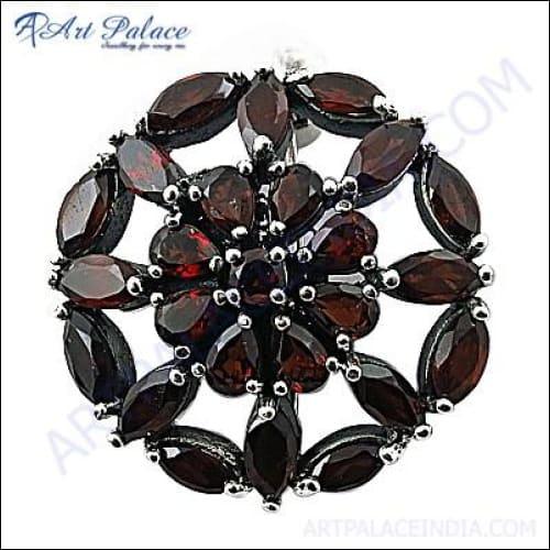 A stunning silver brooch featuring a beautiful flower design with a captivating garnet gemstone at its center, handcrafted by artisans.