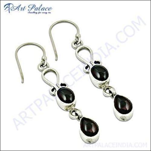 A pair of stunning garnet gemstone earrings featuring intricate designs and a deep red hue, elegantly displayed on a soft background.