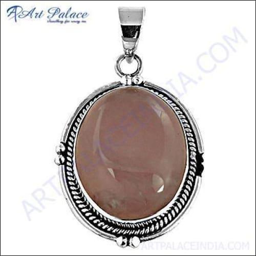 A stunning round rose quartz gemstone set in an elegant silver pendant, showcasing its soft pink hue and intricate design.