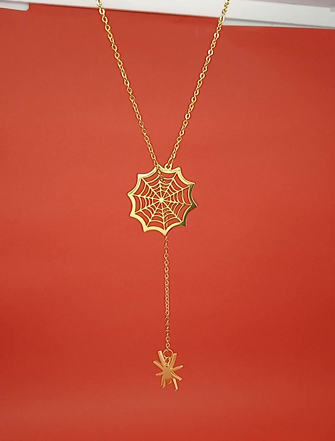 Elegant 18k gold spider necklace with charm pendant, adjustable chain, perfect for Halloween.