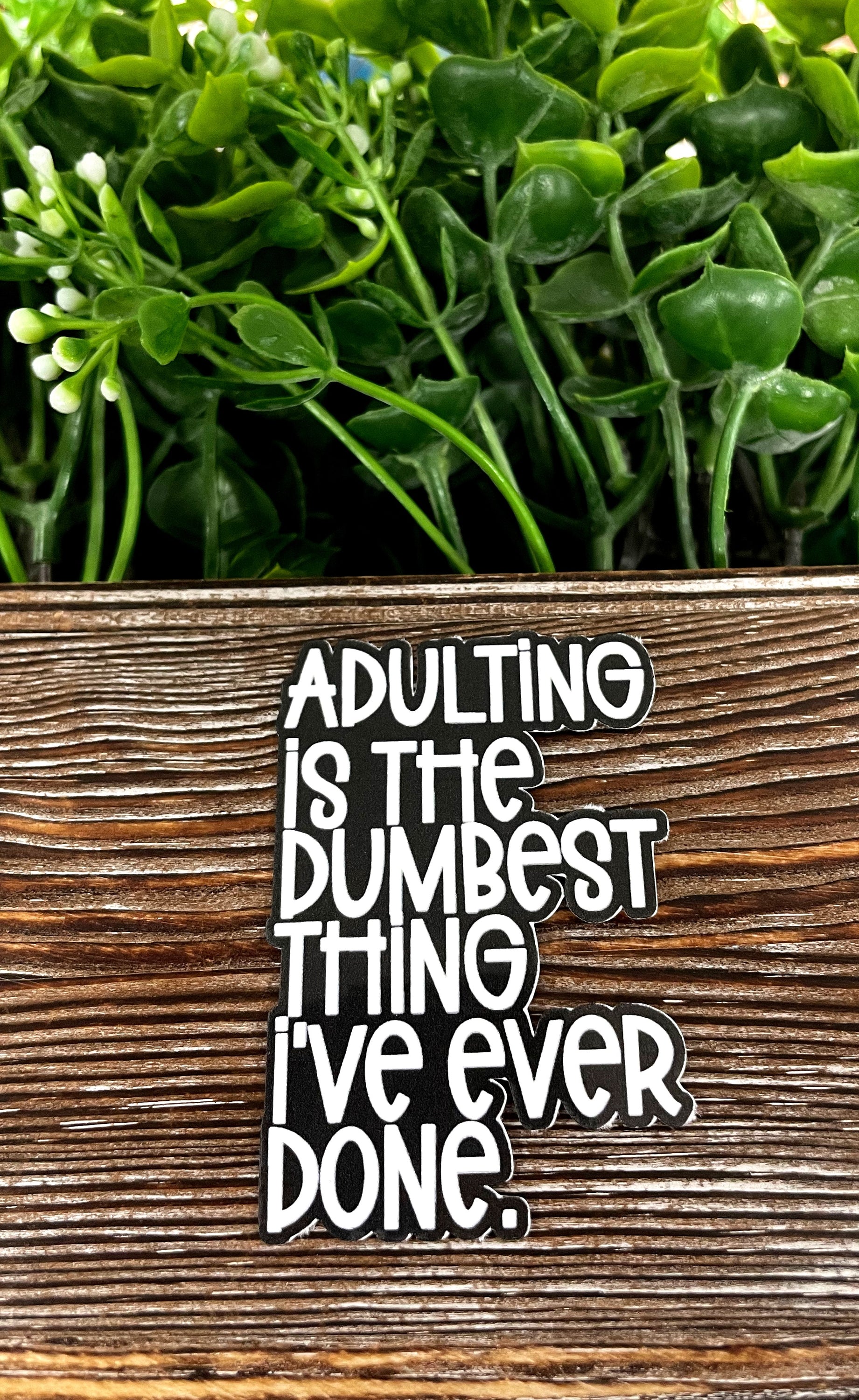Adulting is the Dumbest Thing I've Ever Done die cut vinyl sticker on a smooth surface, showcasing its vibrant colors and design.