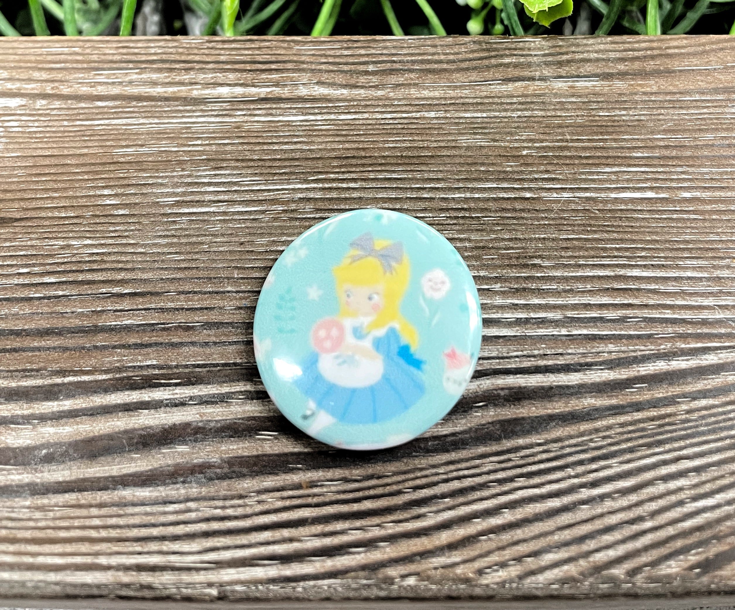 Alice Blue Dress Fairy Tale graphic art button pin, 1.25 inches, featuring vibrant colors and intricate design.