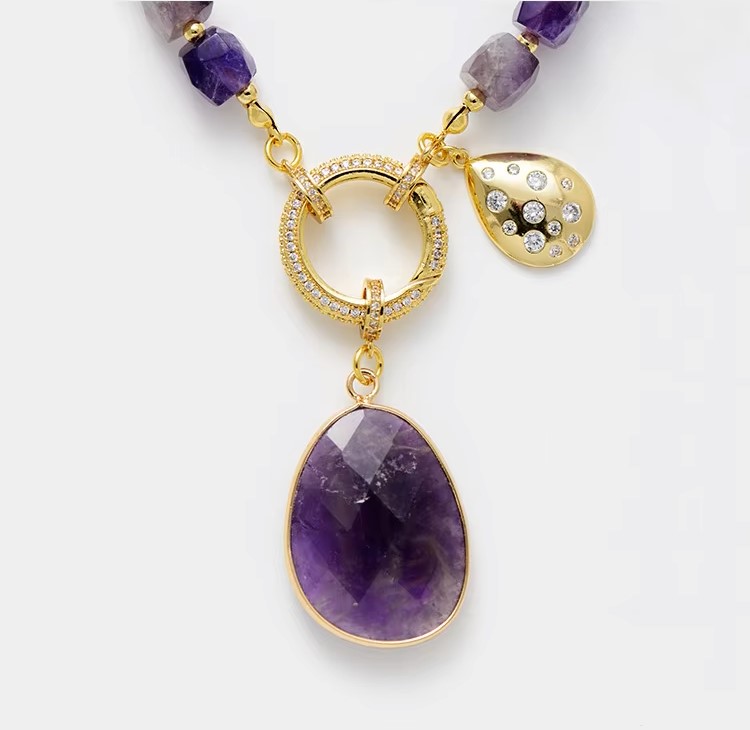 Elegant amethyst crystal pendant necklace on a gold plated chain, showcasing its stunning purple hues.